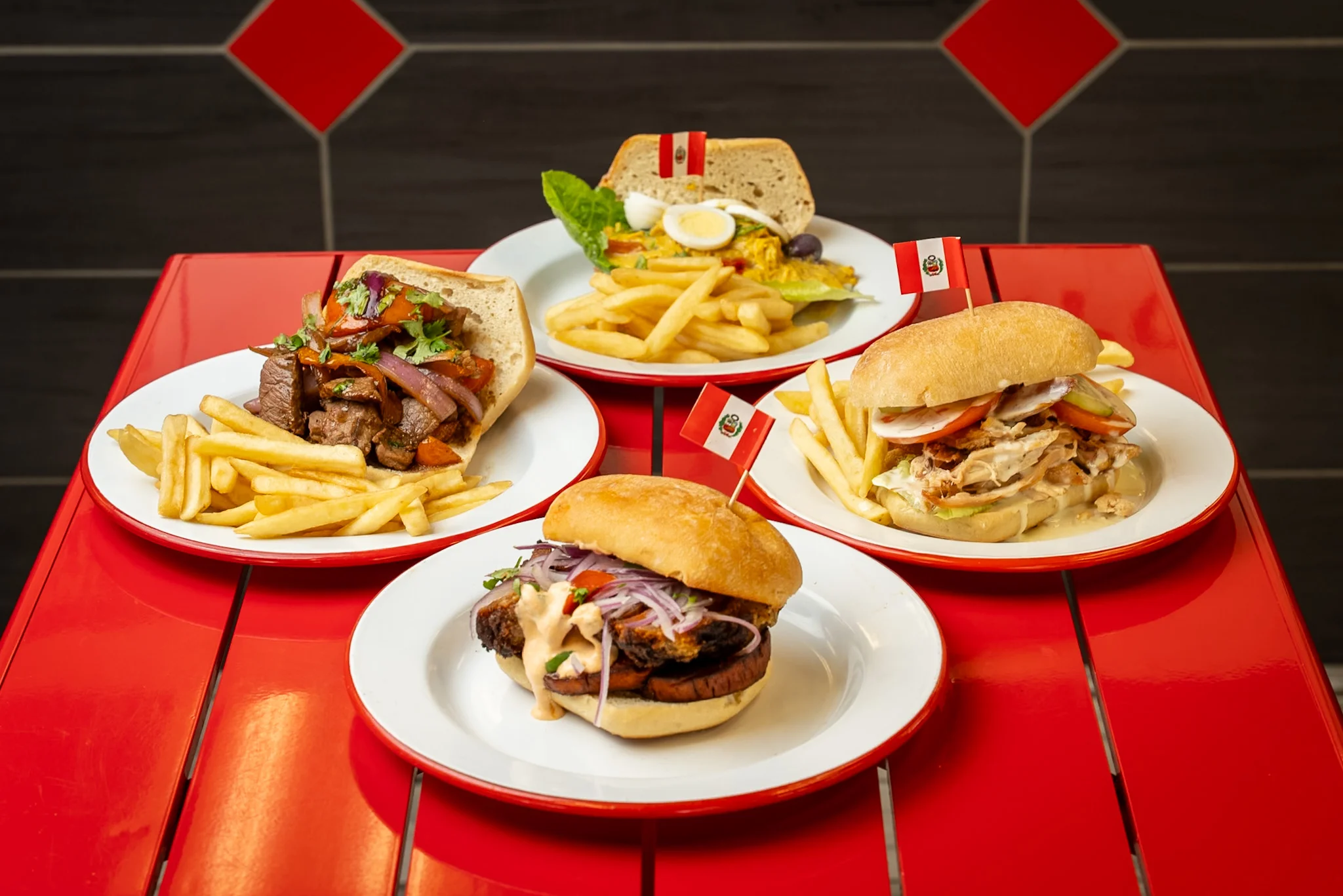 Peruvian sandwiches with fries on a vibrant red table
