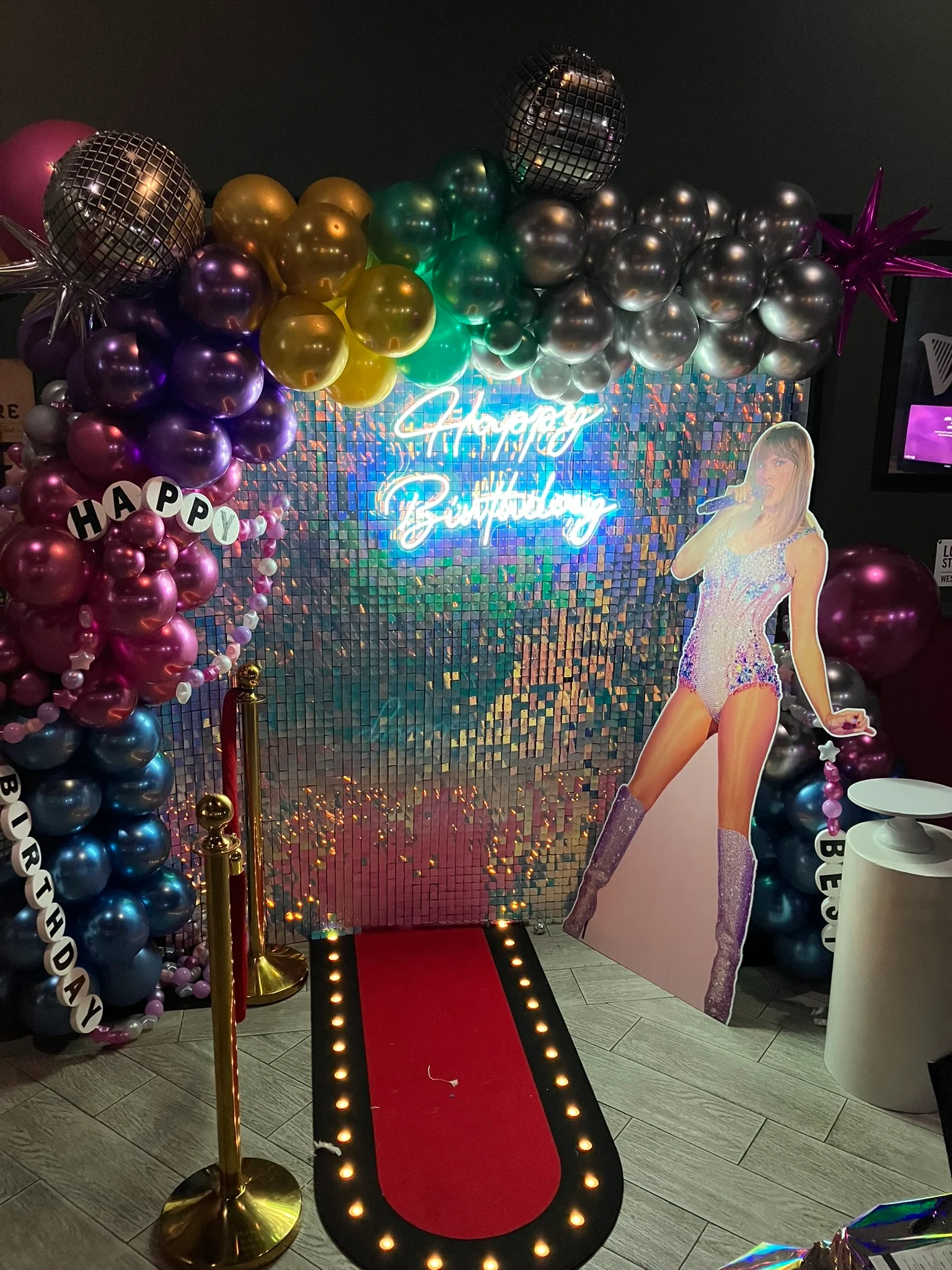 Colorful birthday party backdrop with neon sign and red carpet