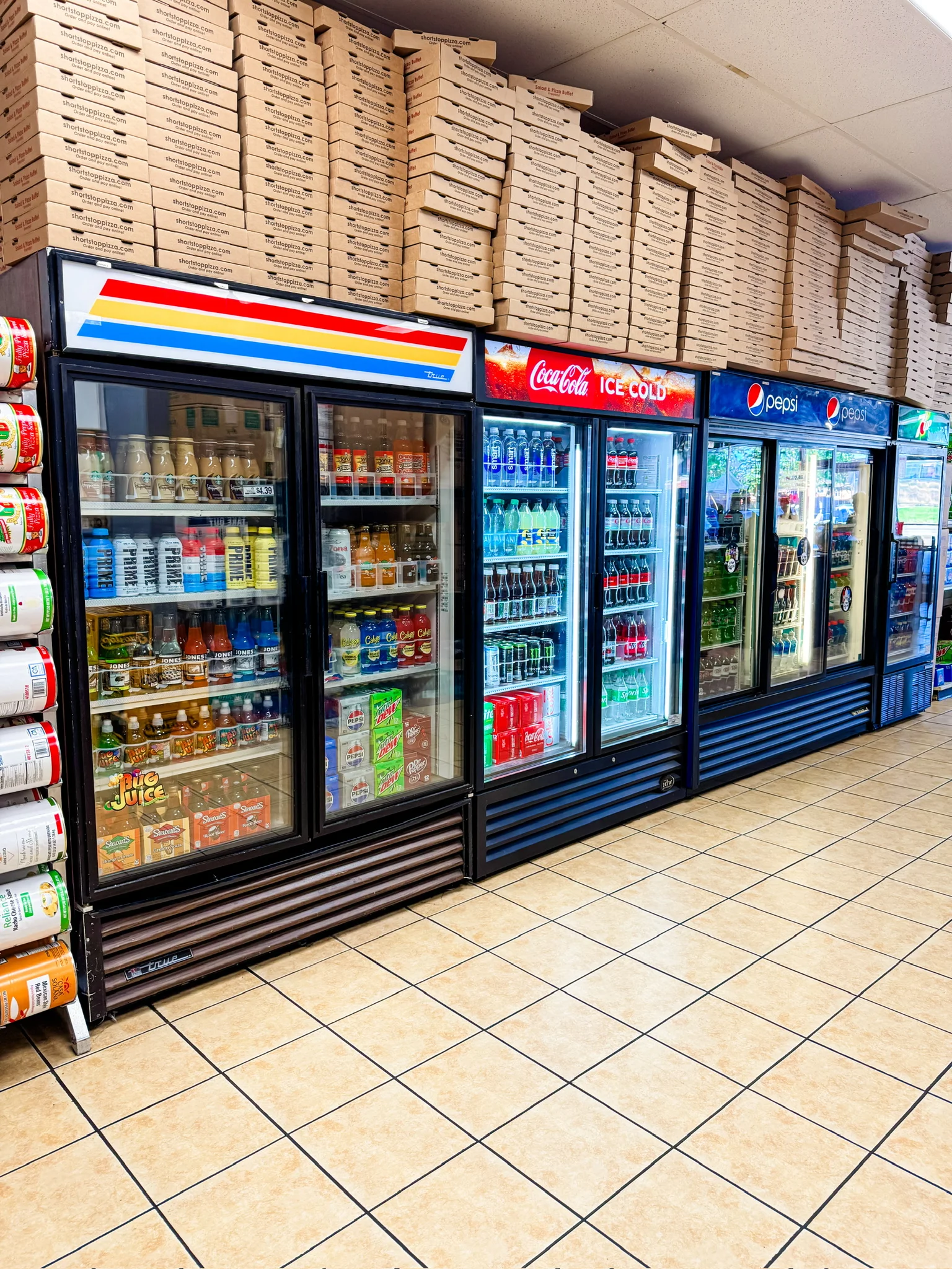 Beverage coolers stocked with drinks in a pizza shop