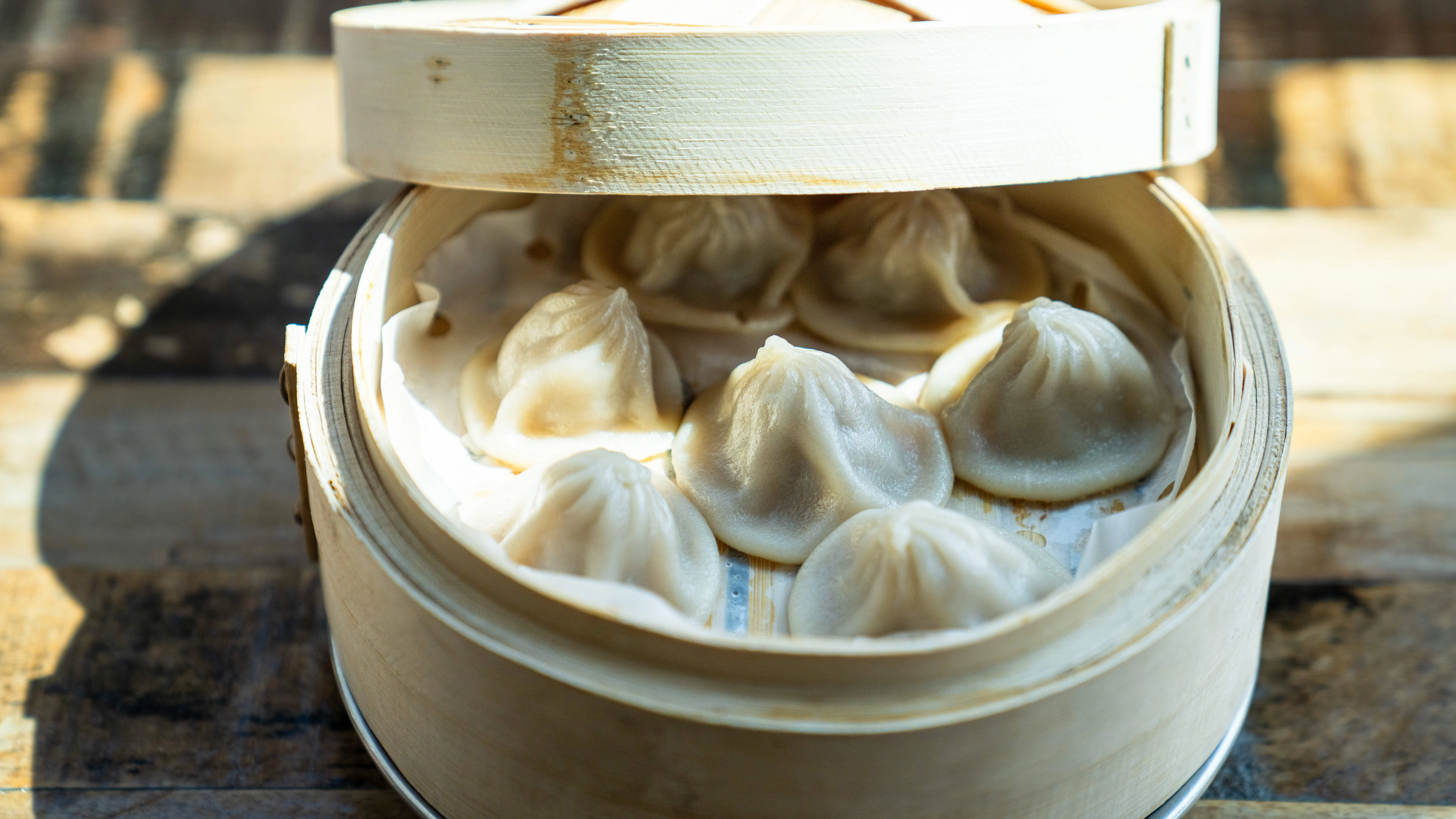 Steamed Chinese xiao long bao dumplings in a bamboo steamer