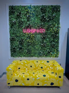 Vibrant seating area with floral couch and greenery wall decor