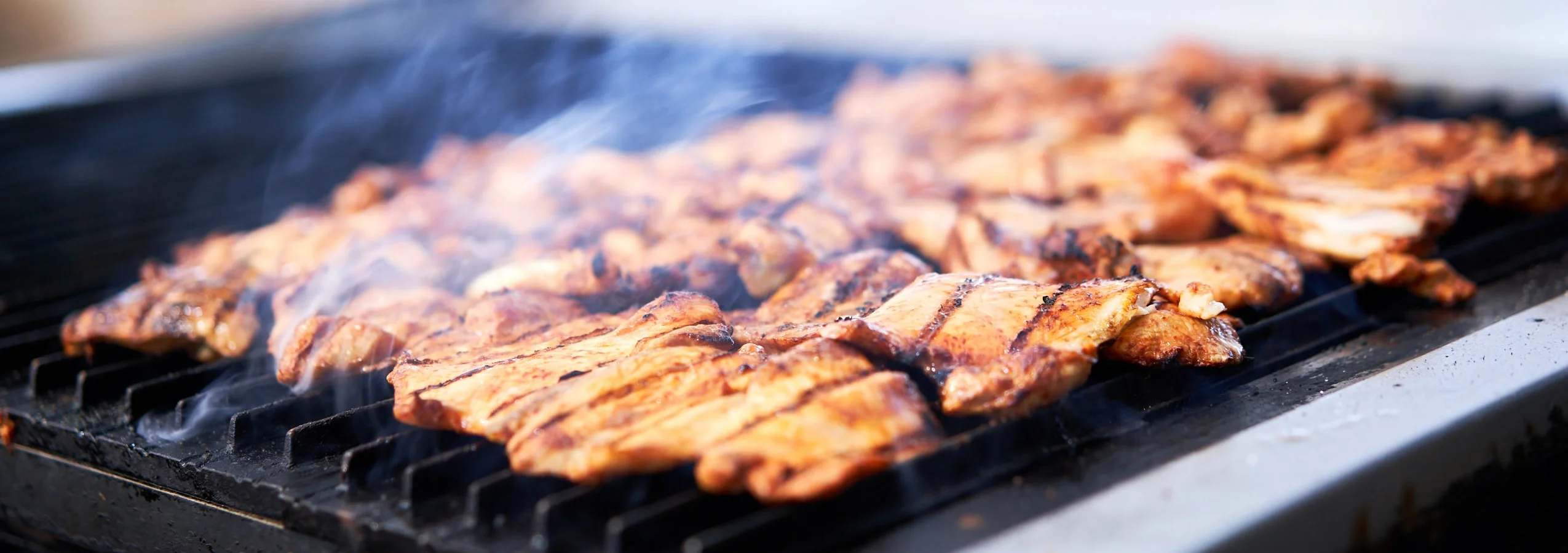 Grilled chicken skewers sizzling on a barbecue