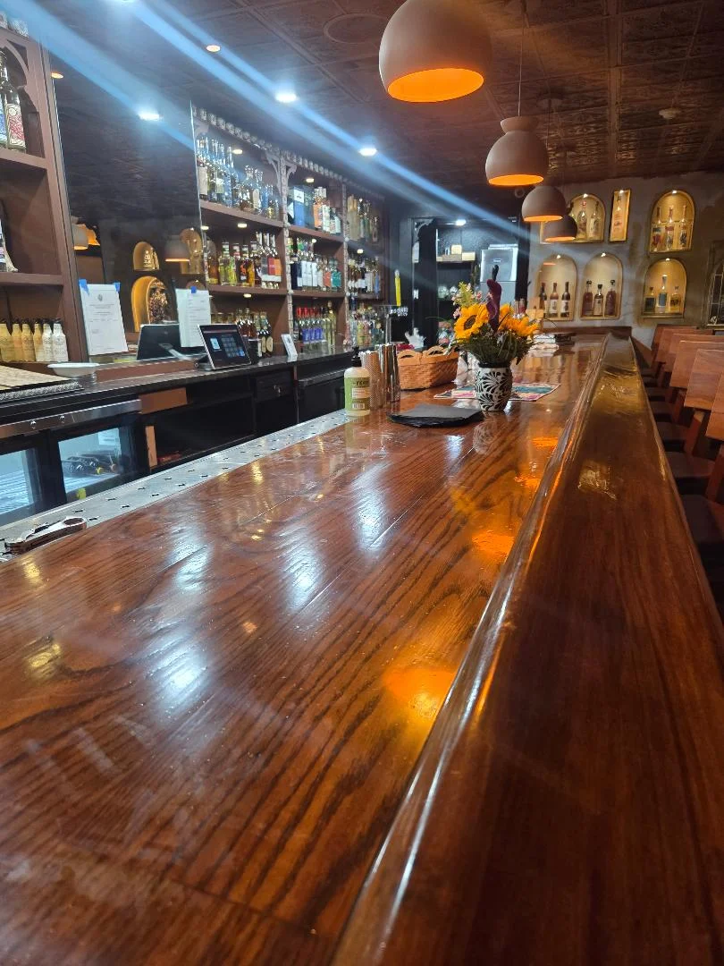 Stylish bar interior with wooden counter and shelves of spirits