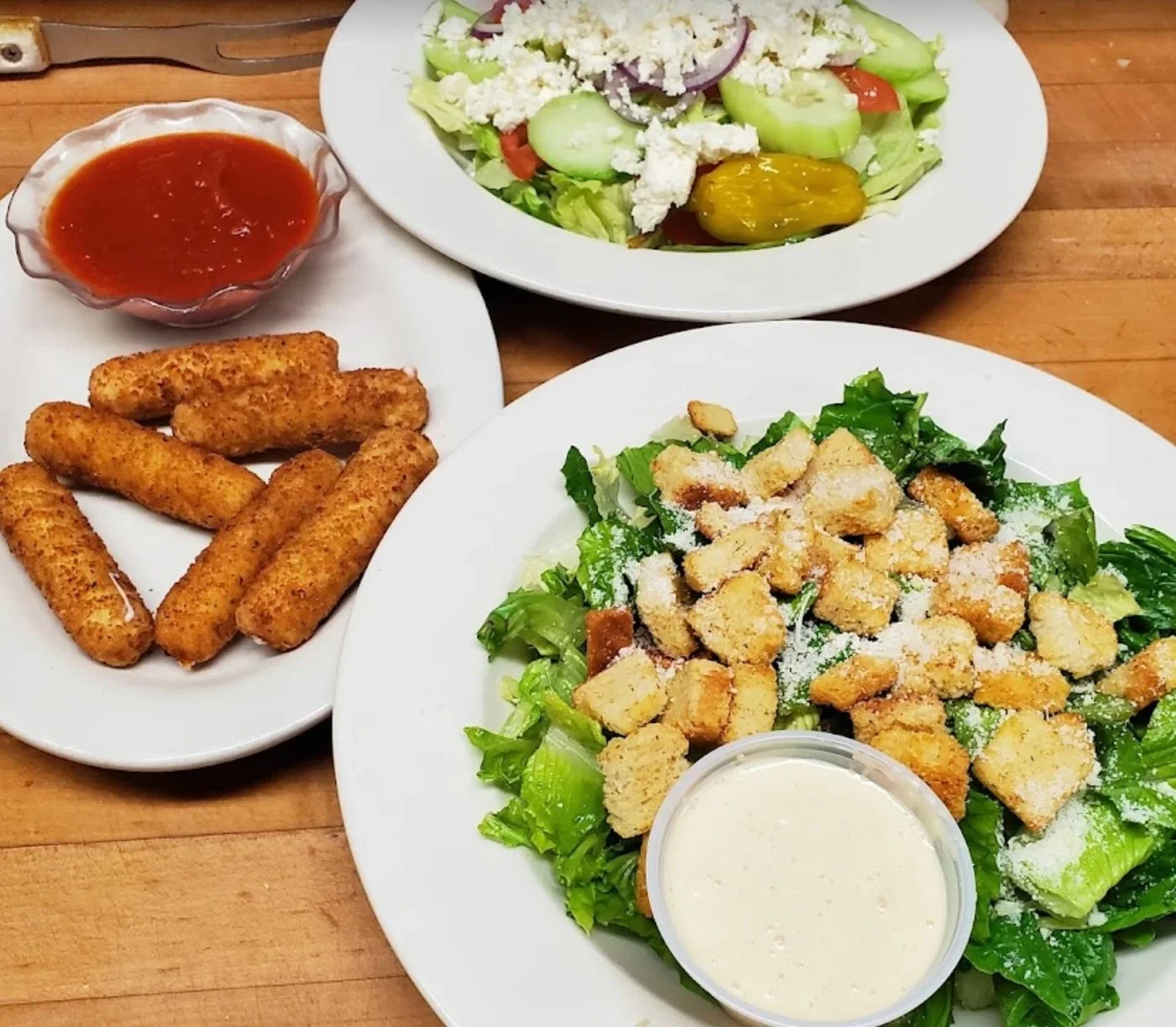 Mozzarella sticks with marinara, a Caesar salad and a Greek salad from Patio Italian Kitchen