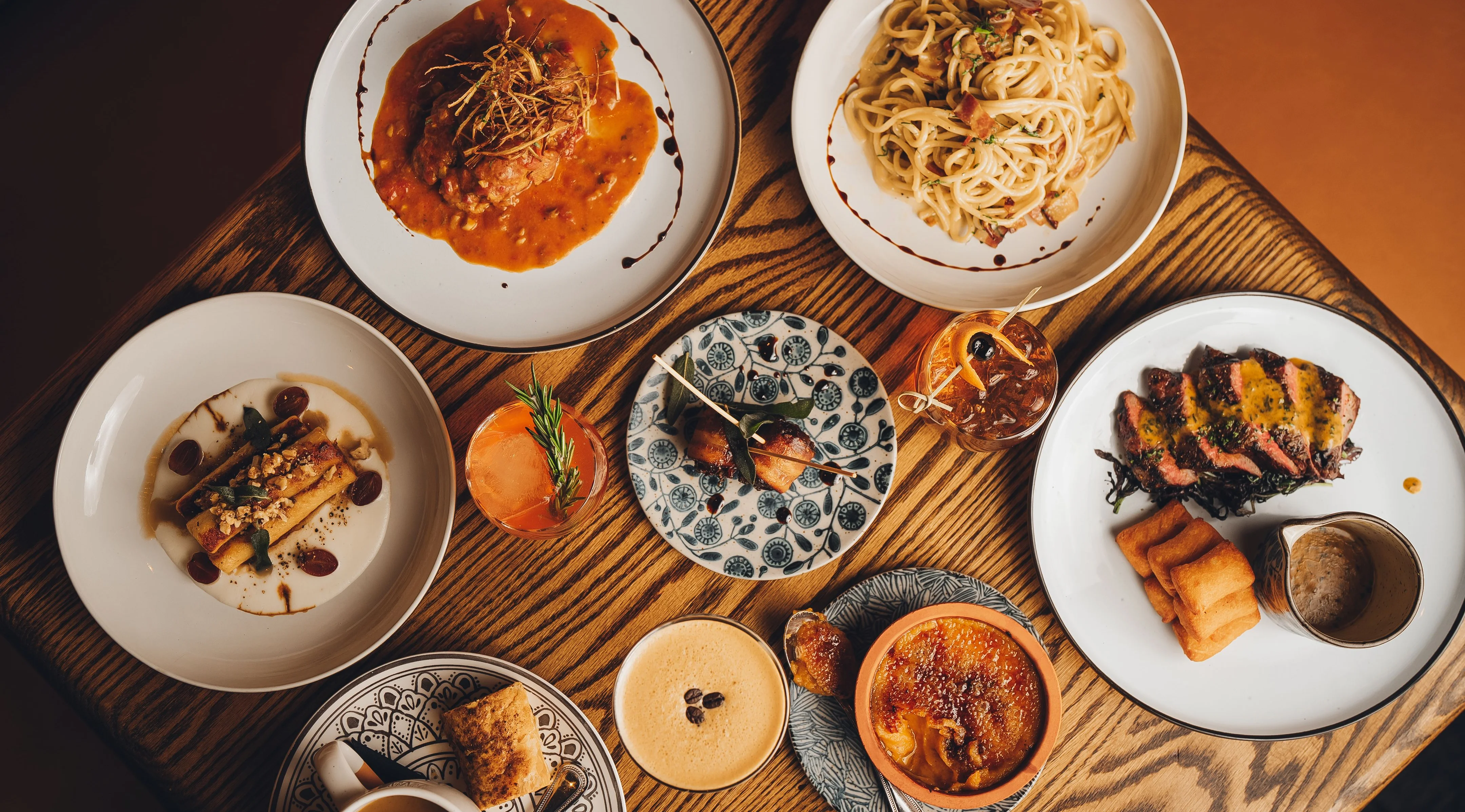 Assorted gourmet dishes including pasta and steak