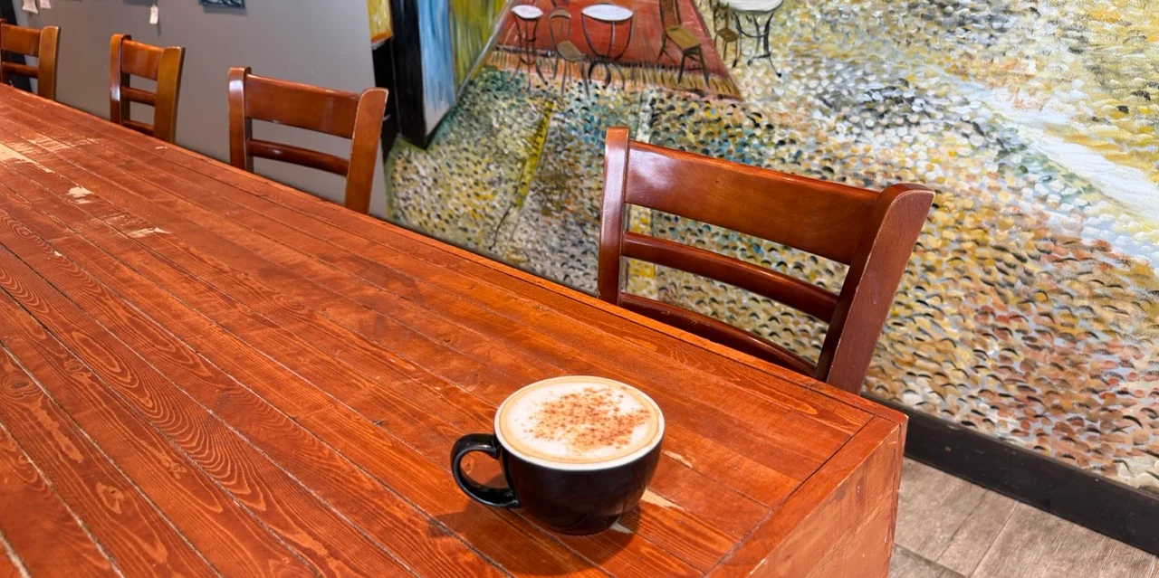 A cup of specialty coffee on a wooden bar.