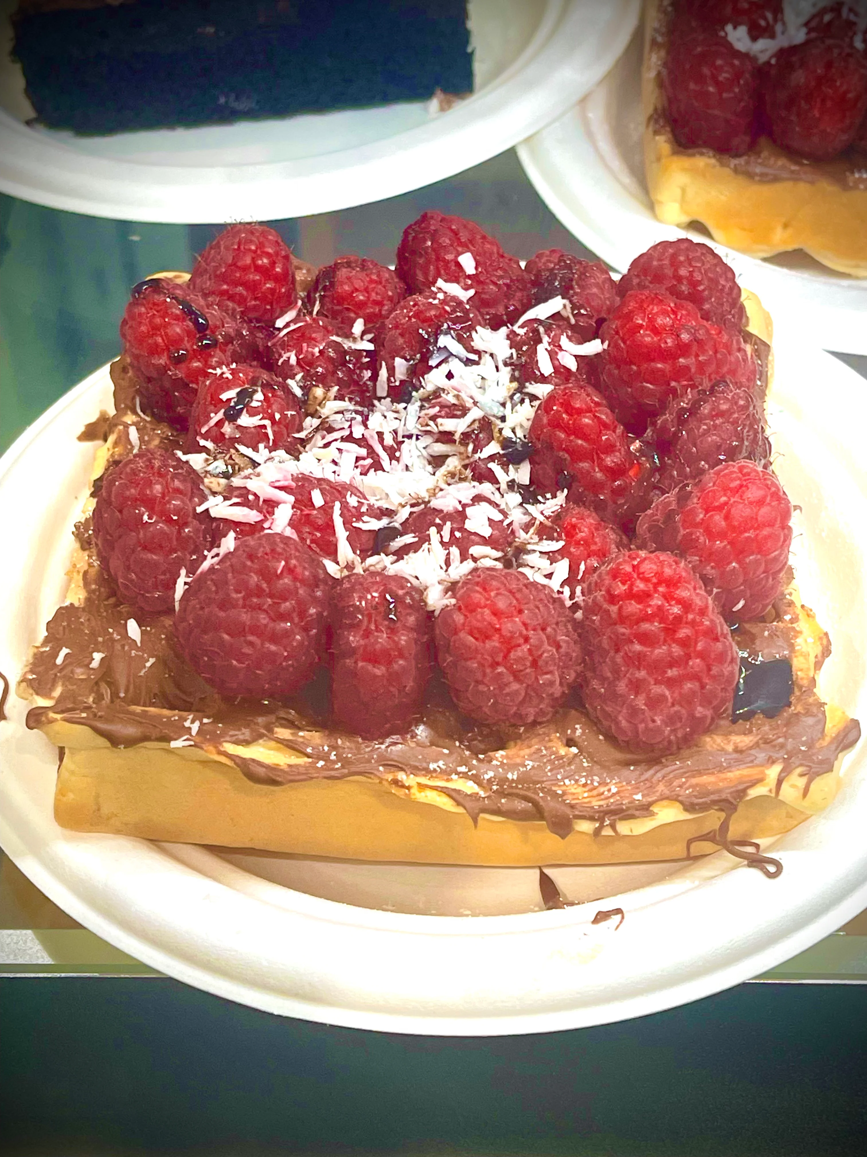 Decadent Belgian waffle topped with raspberries and coconut