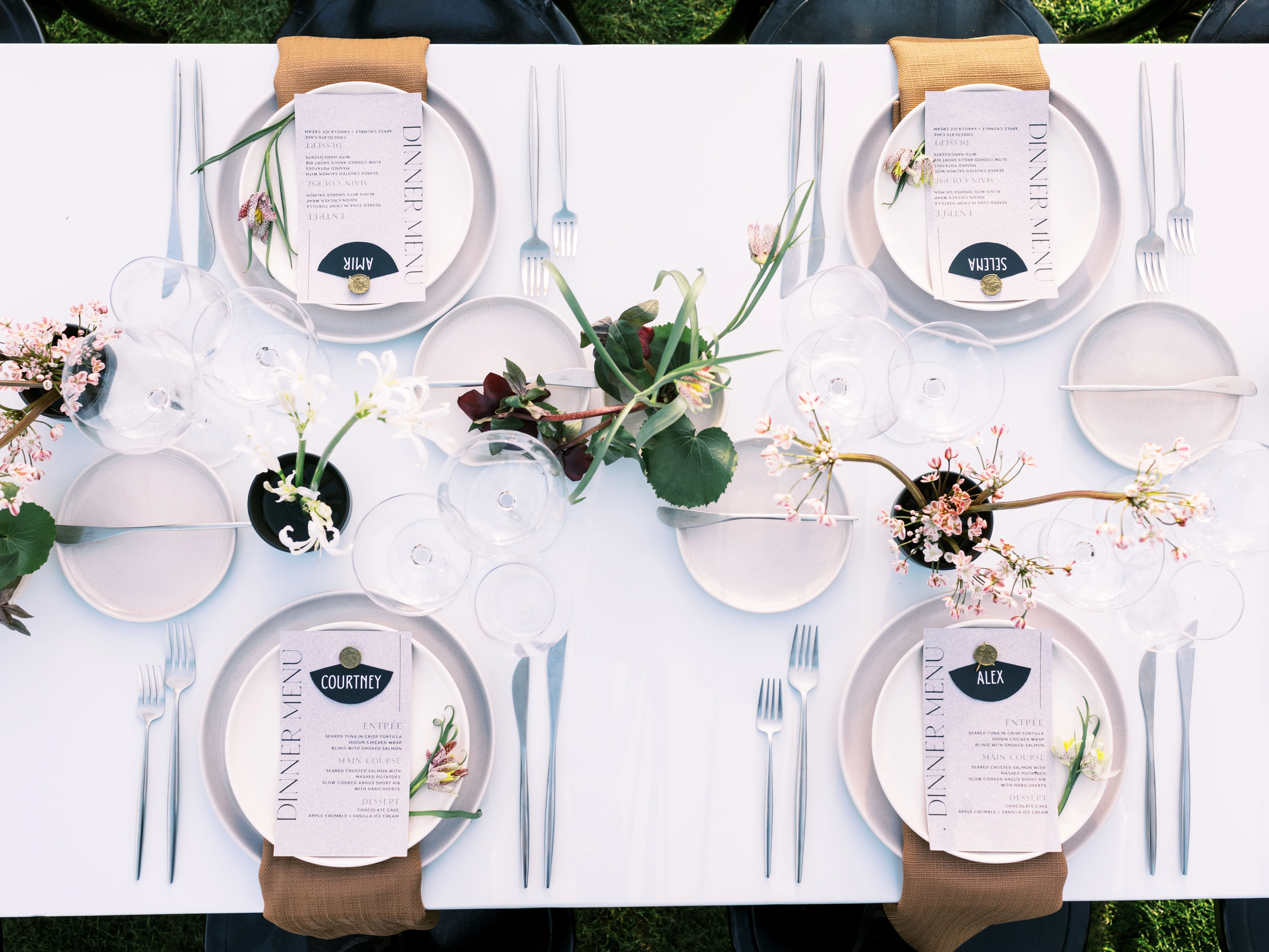 Elegant dinner table setting with personalized menus and floral arrangements
