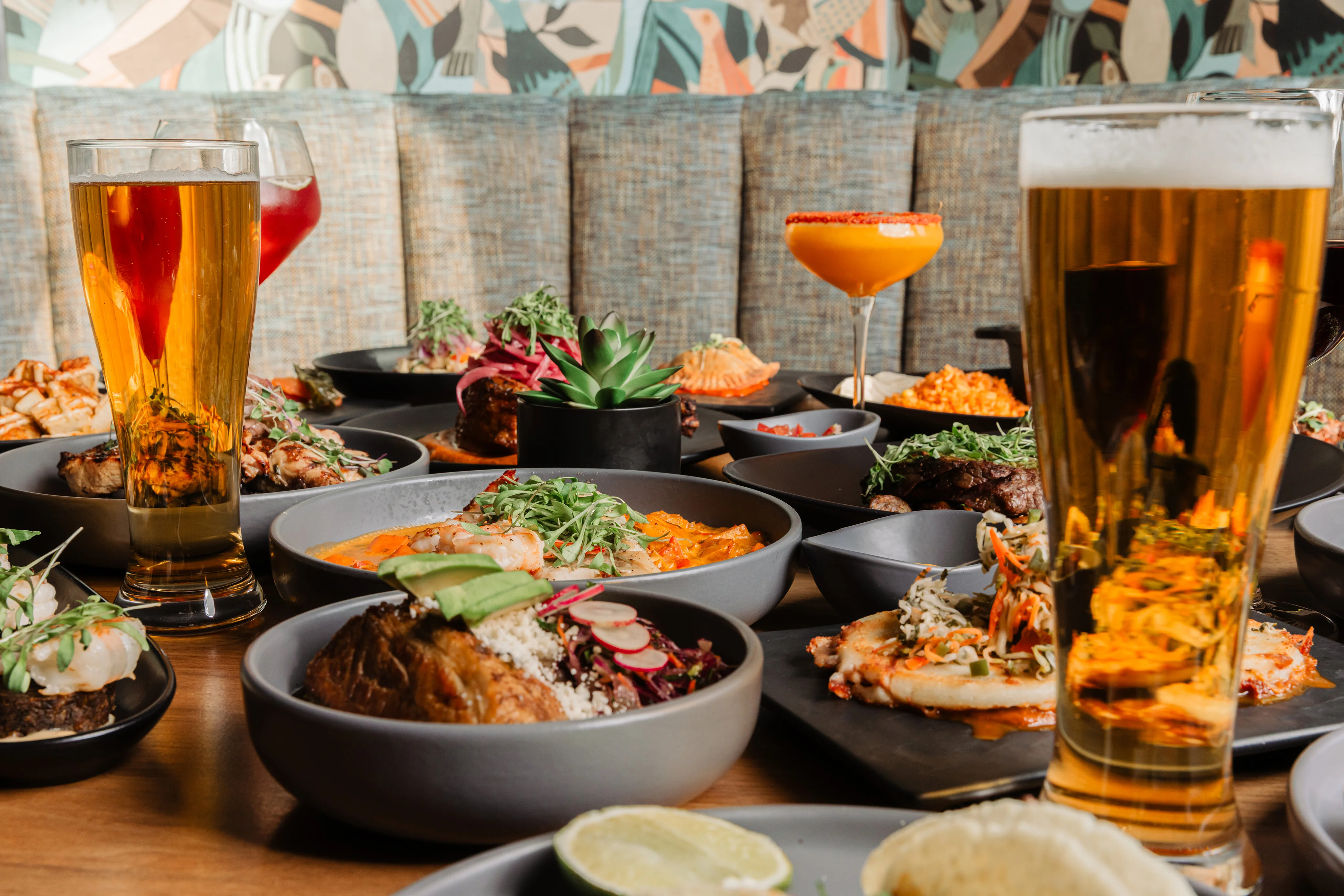 Colorful spread of Mexican dishes with craft cocktails