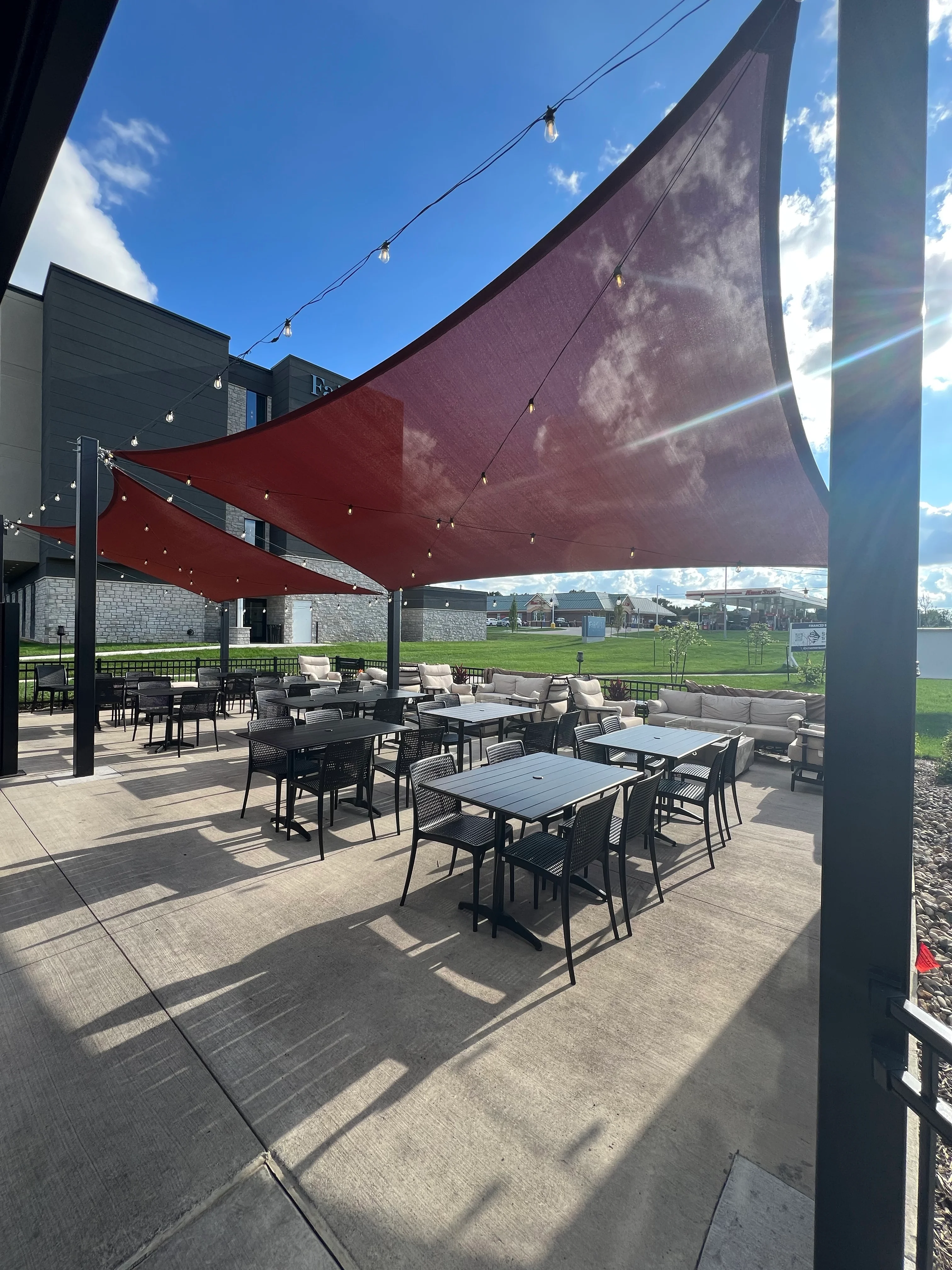 Outdoor dining area with shaded seating and string lights
