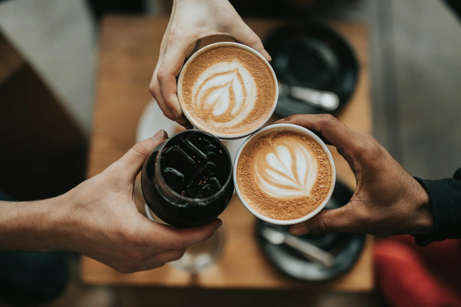 Coffee cups with latte art and iced coffee in a cozy café setting