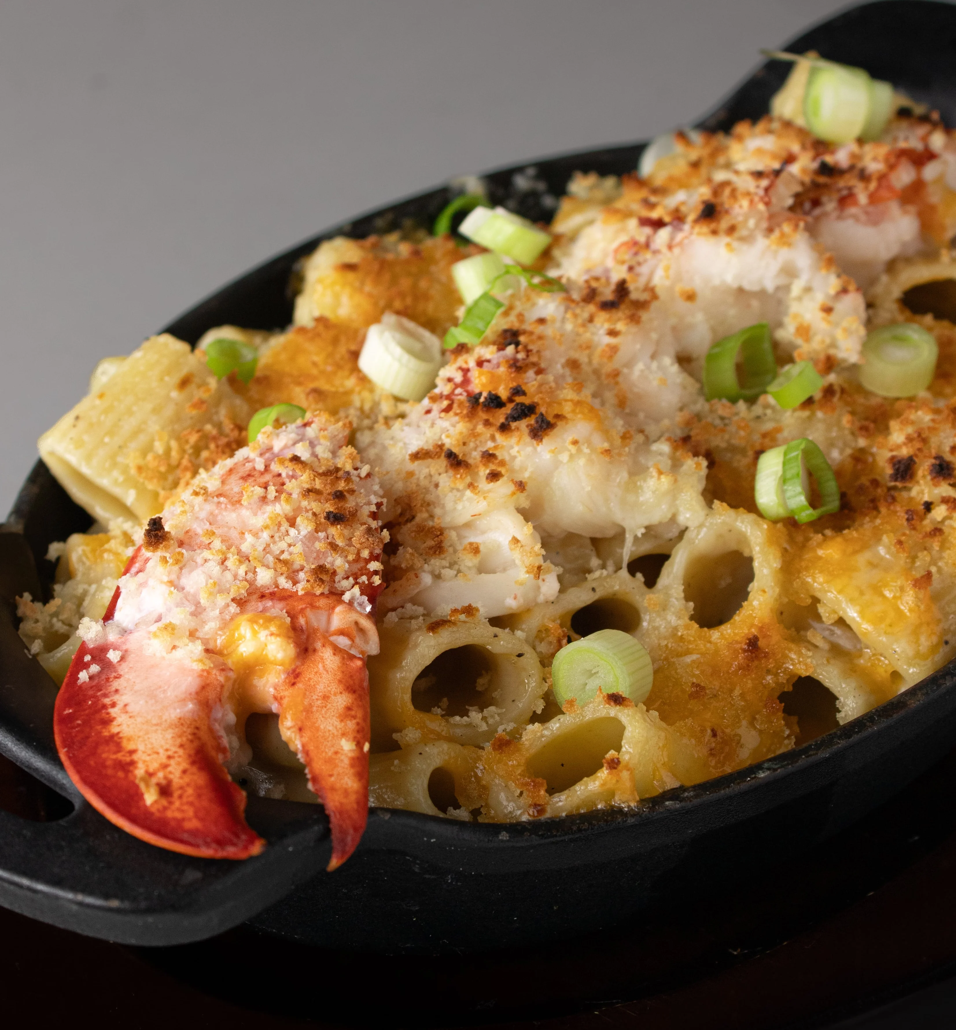Lobster mac and cheese in a sizzling cast iron skillet