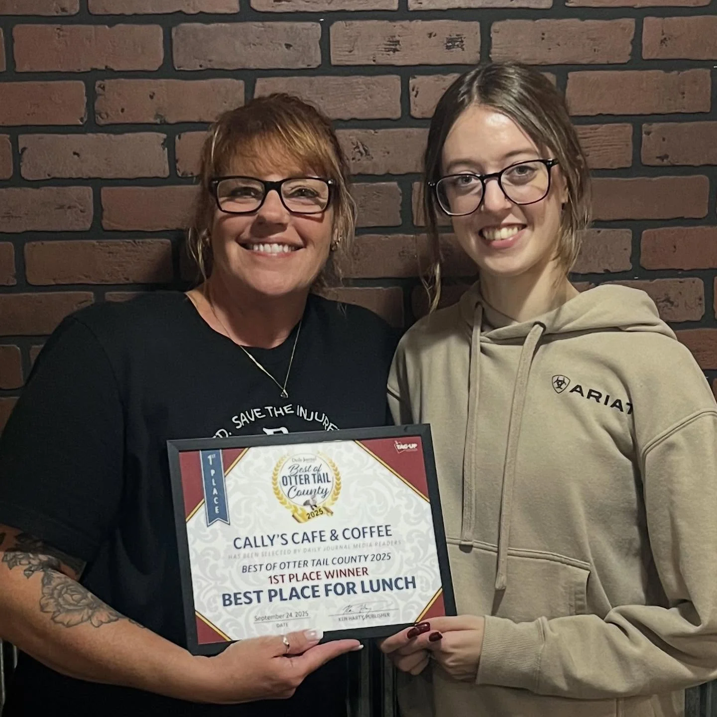 Smiling restaurant team presenting a best lunch award certificate