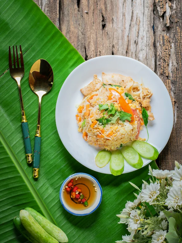Plate of Thai fried rice with chicken and fresh vegetables