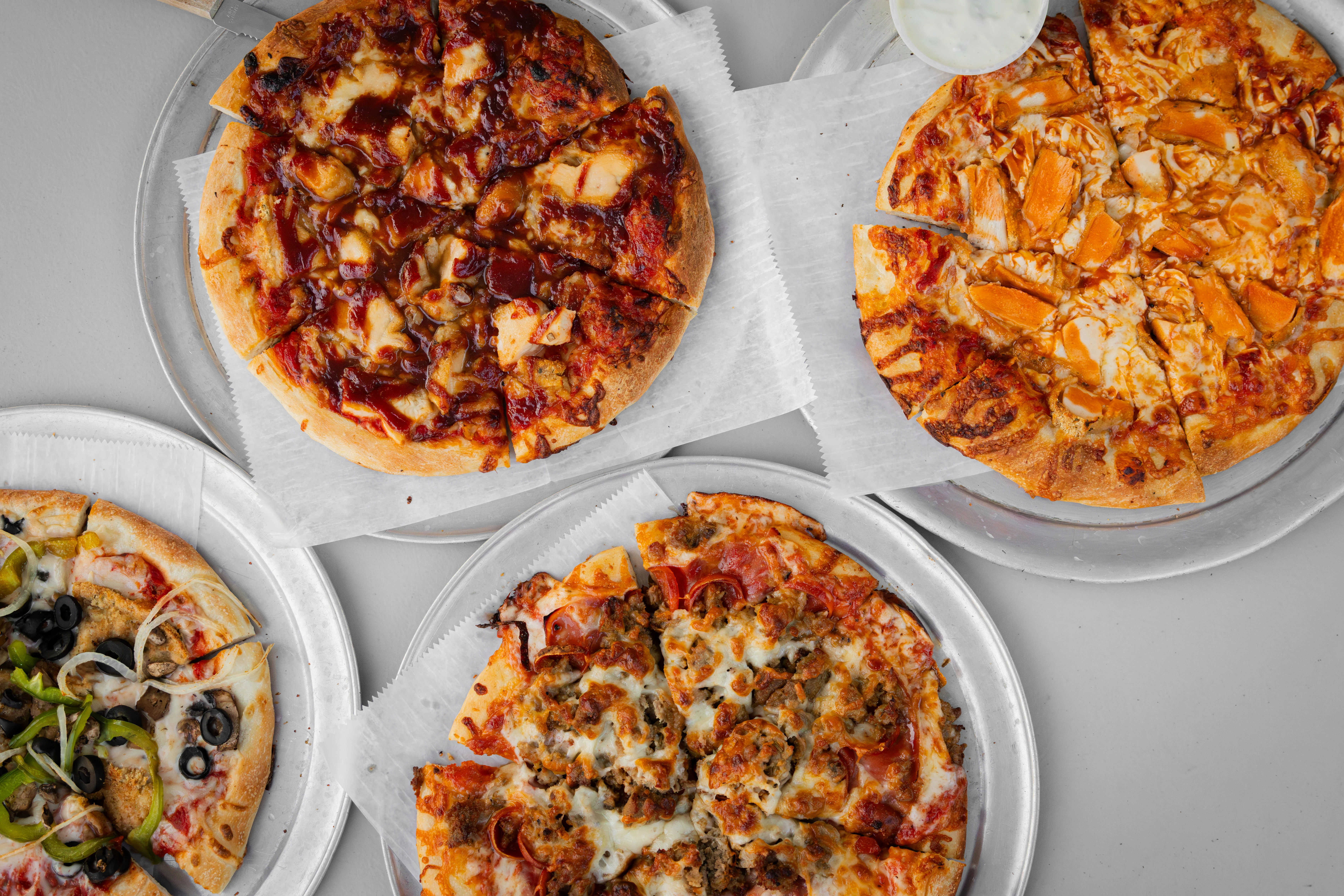 Variety of pizzas including BBQ chicken and meat lovers
