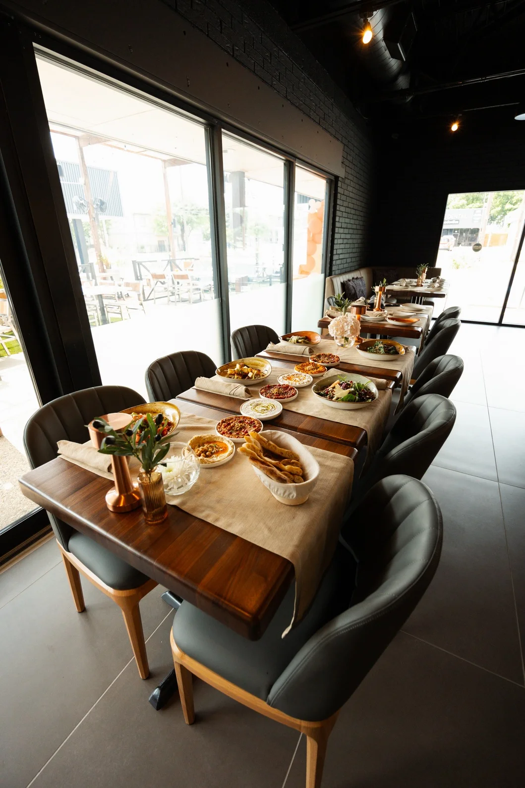 A beautifully set dining table with an array of dishes, including salads, spreads, and assorted appetizers. The table is adorned with elegant decor and has a warm ambiance.