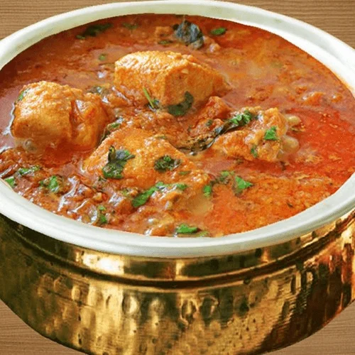 paneer butter masala in a traditional bronze serving bowl.