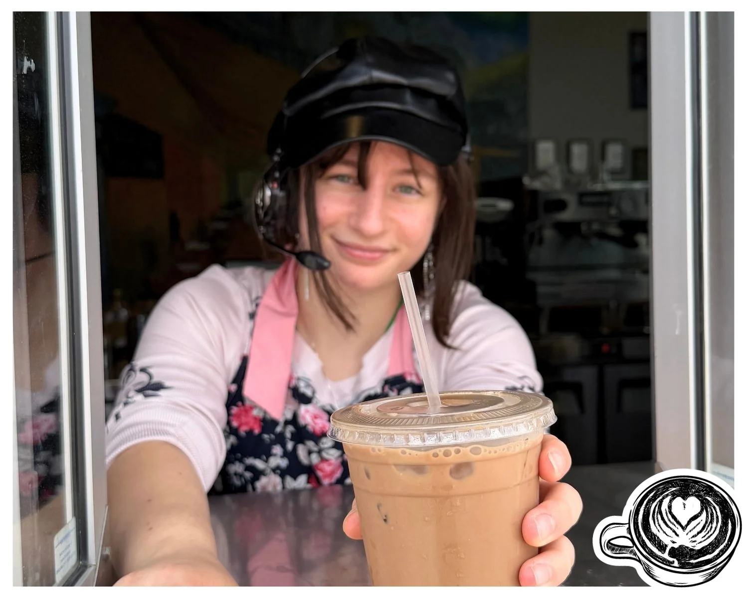 Barista serving iced coffee at a café window