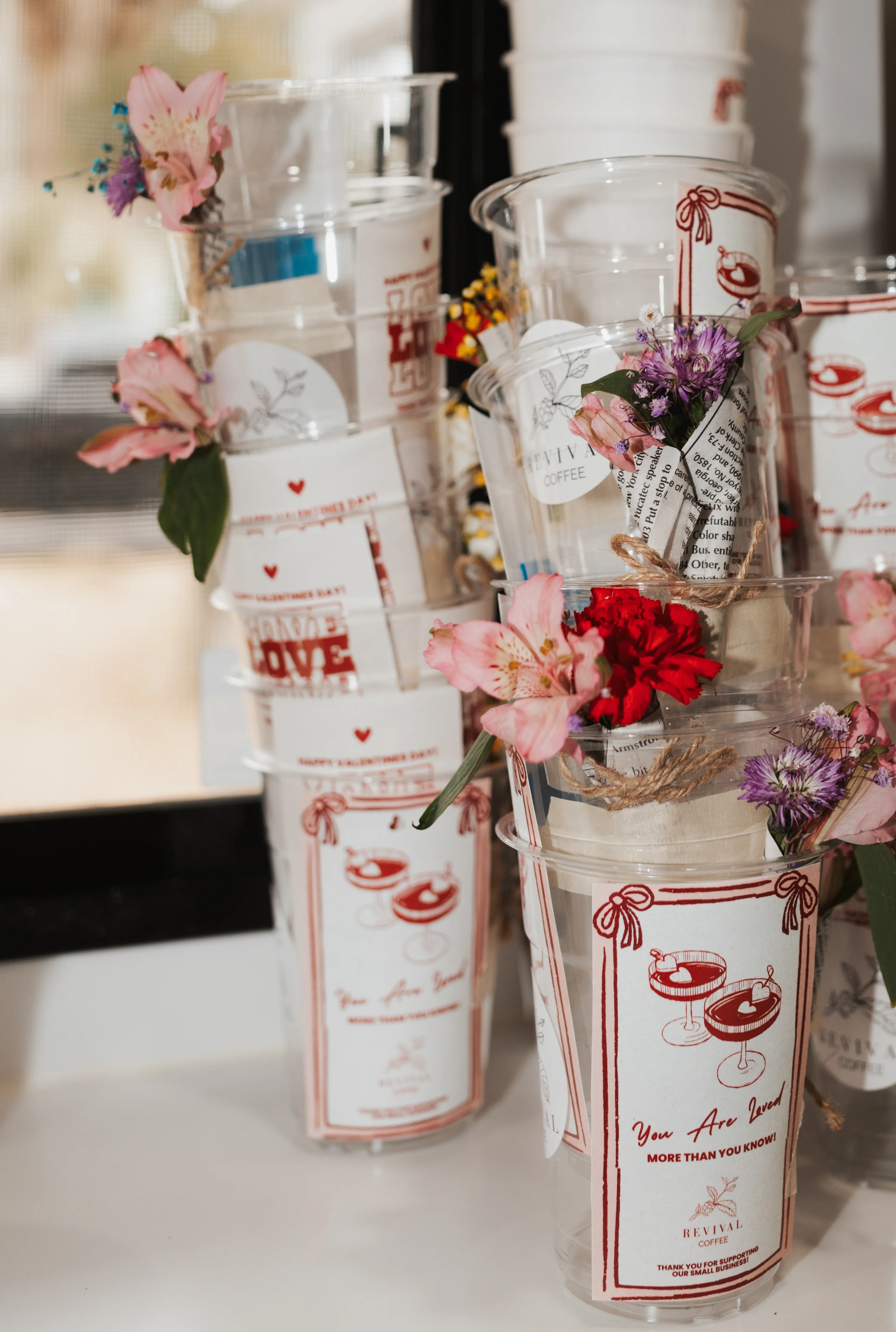 Decorative cups with flowers and labels in a cafe setting