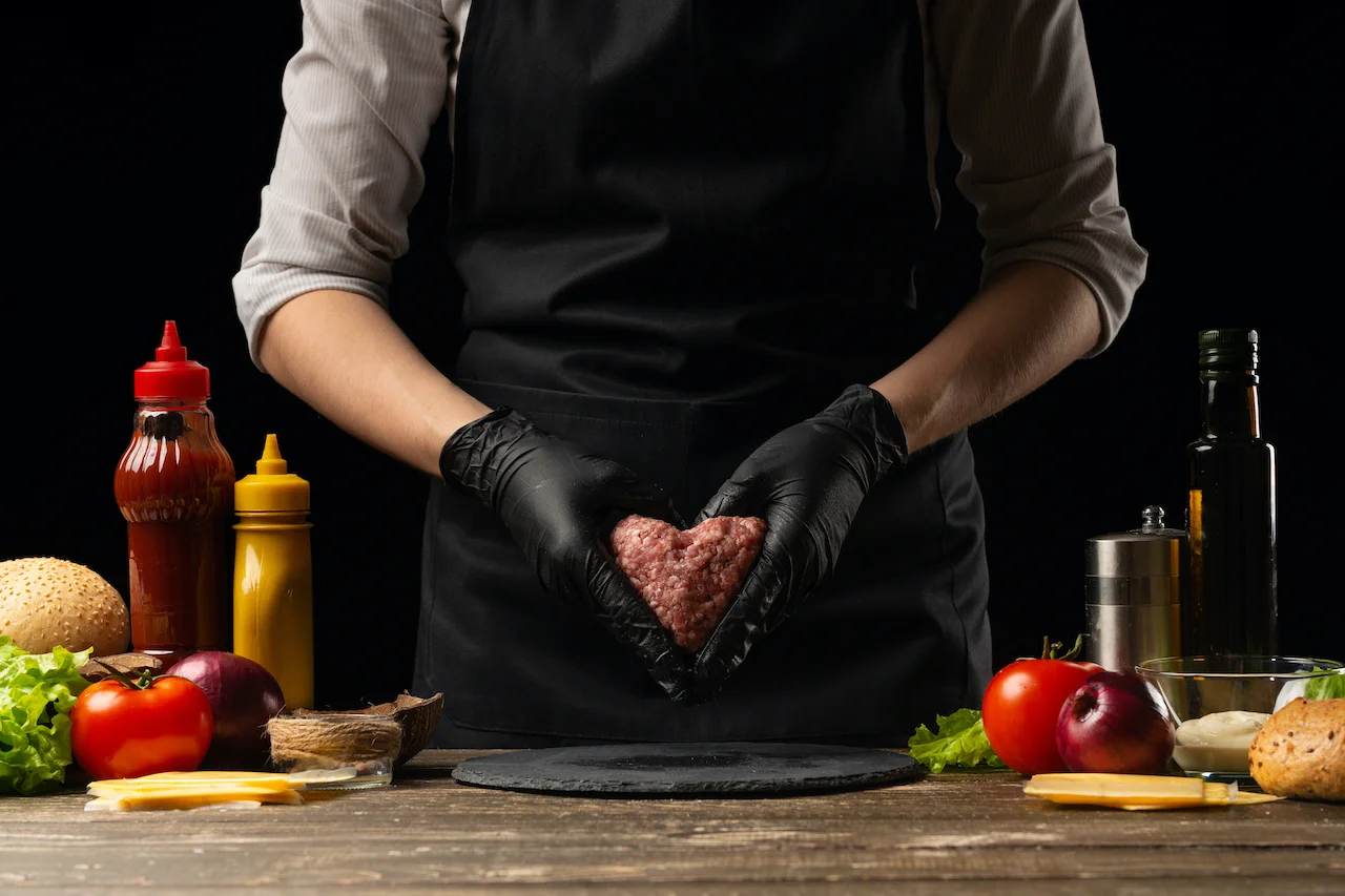 Chef shaping a heart-shaped burger patty for a gourmet dish