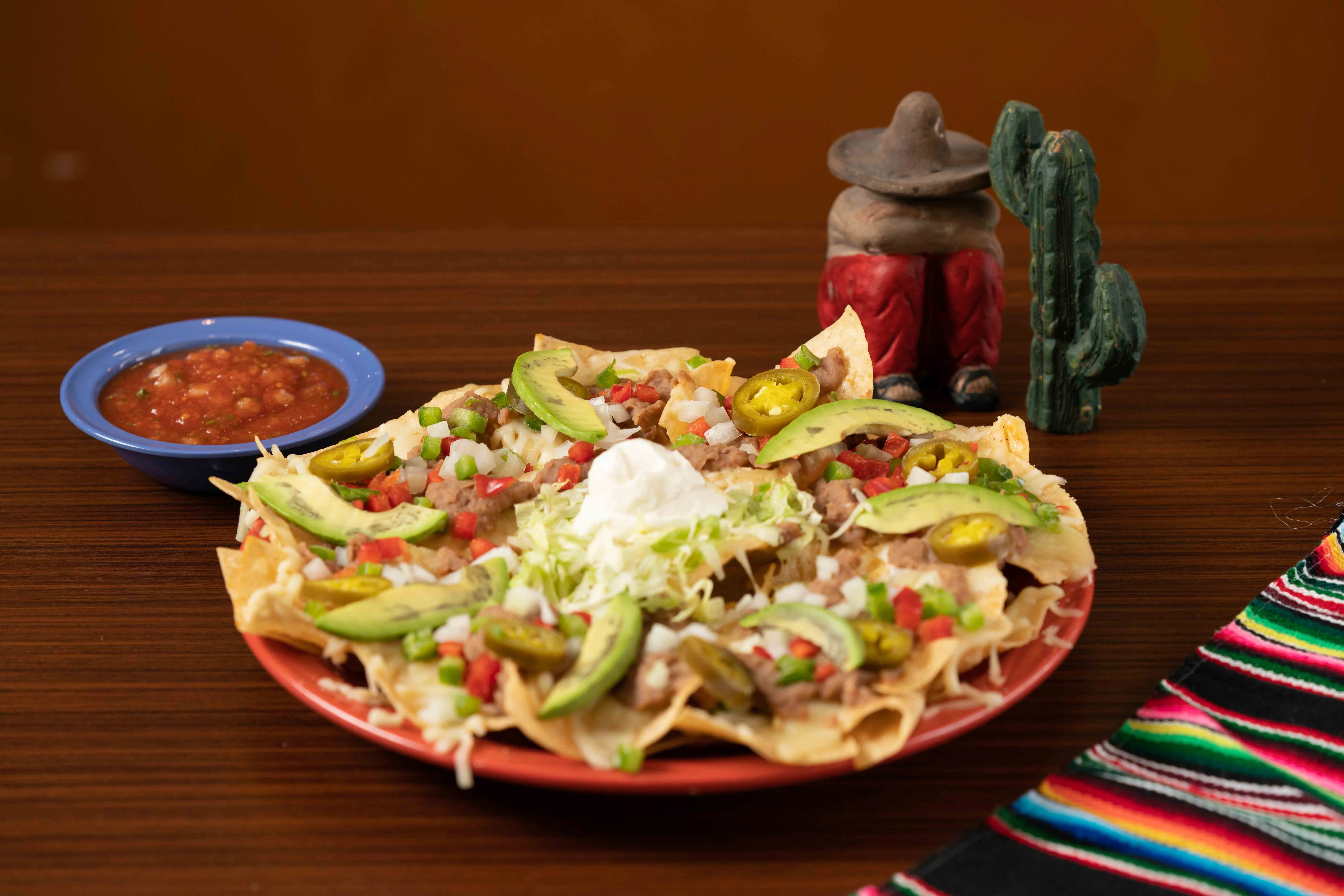 Plate of Mexican nachos topped with fresh ingredients