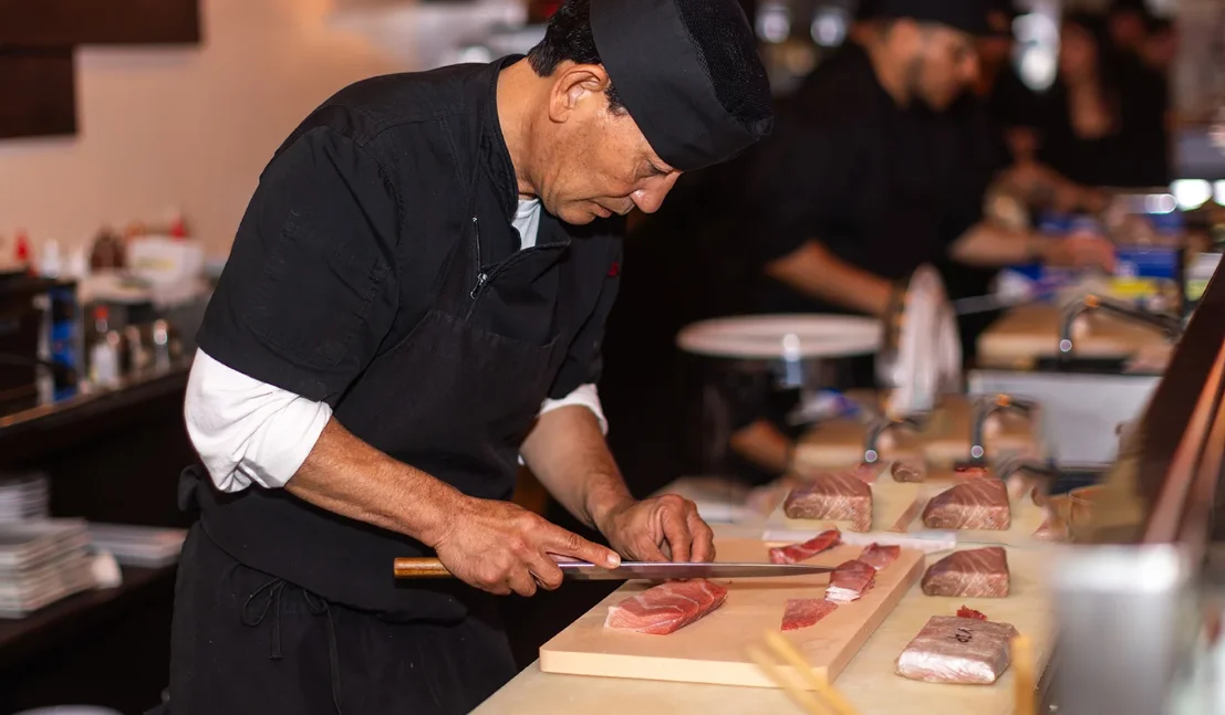 Chef plating assorted nigiri sushi with salmon, tuna, and sashimi at Noir Sushi & Sake Fusion Lounge in Gaslamp San Diego