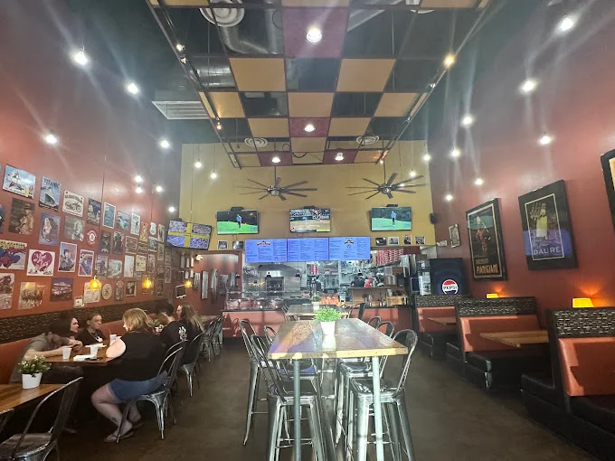 Cozy restaurant interior with vibrant decor and multiple screens