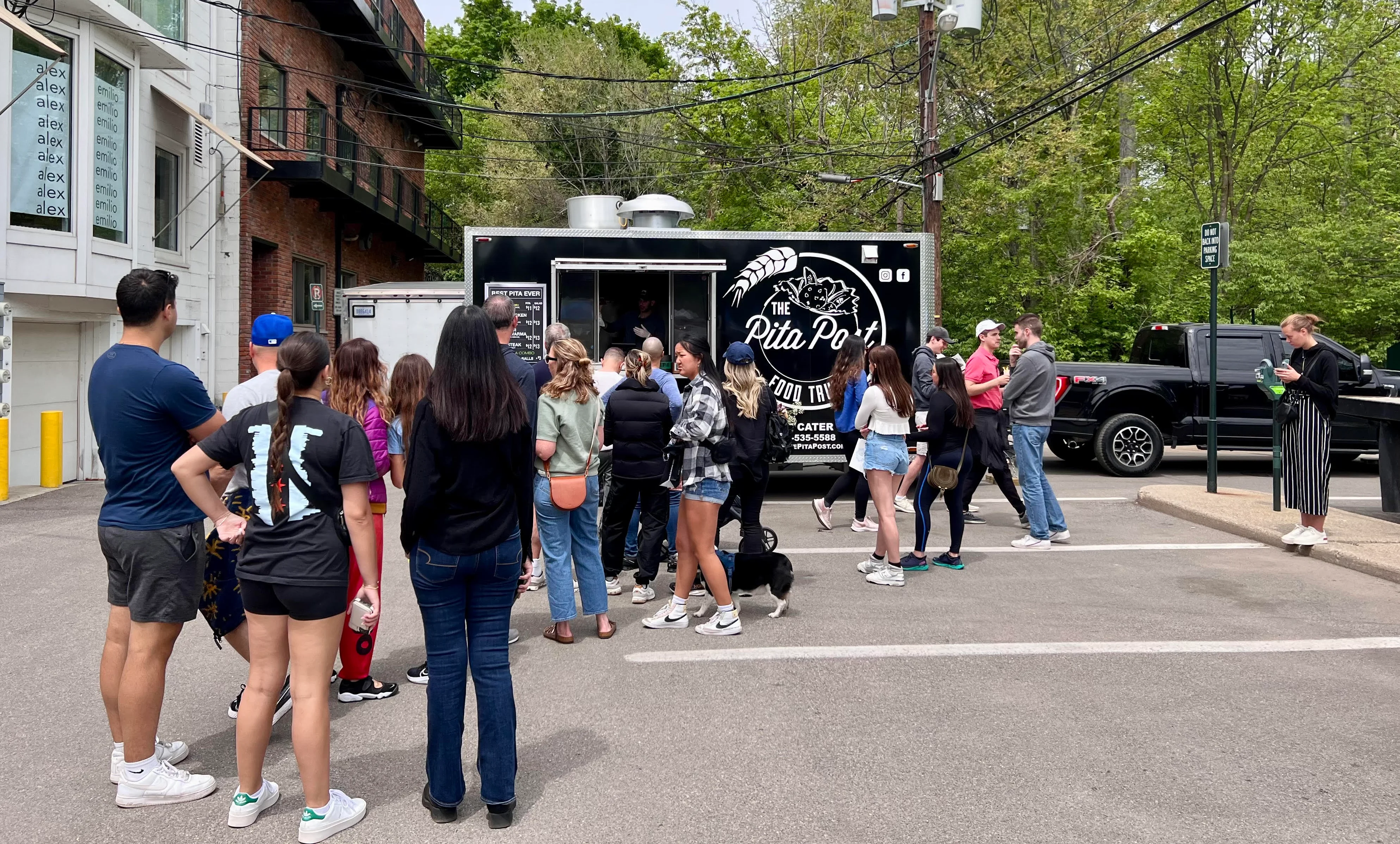 A group of customers standing in line for the Pita Post Food Truck