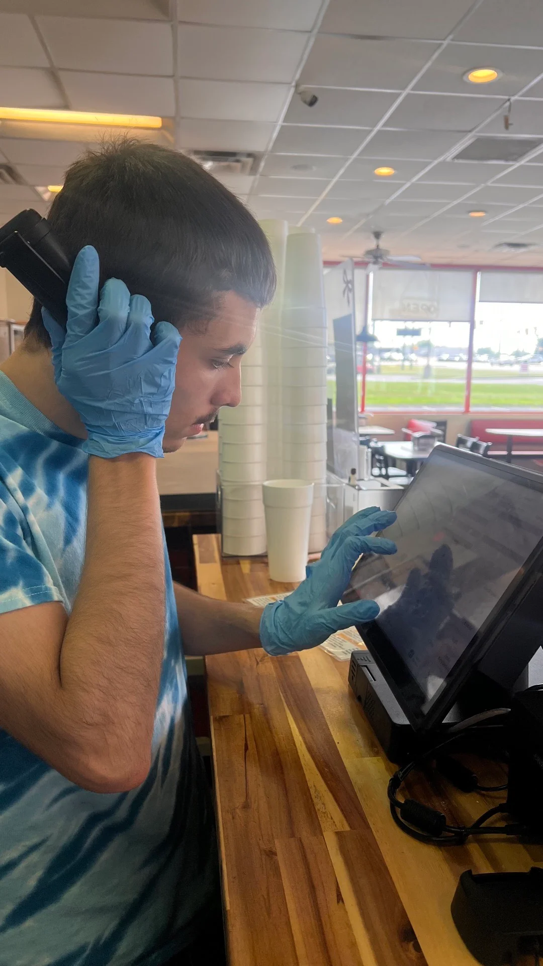 Employee taking a phone order at a restaurant counter