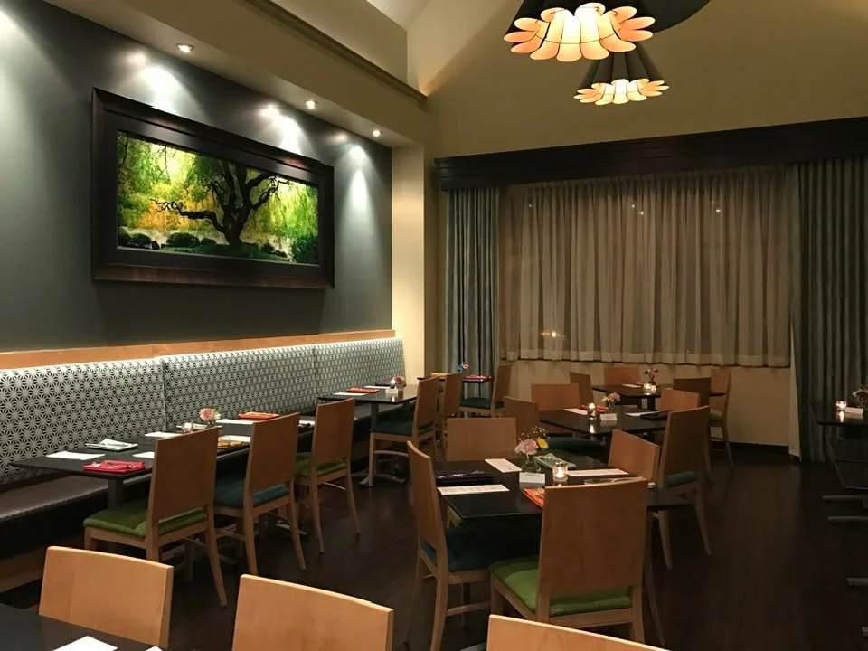 Elegant dining setup with floral arrangements and a large screen