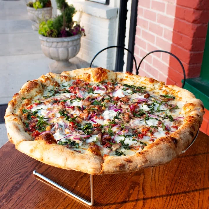 Large meat lover's pizza on a wooden table