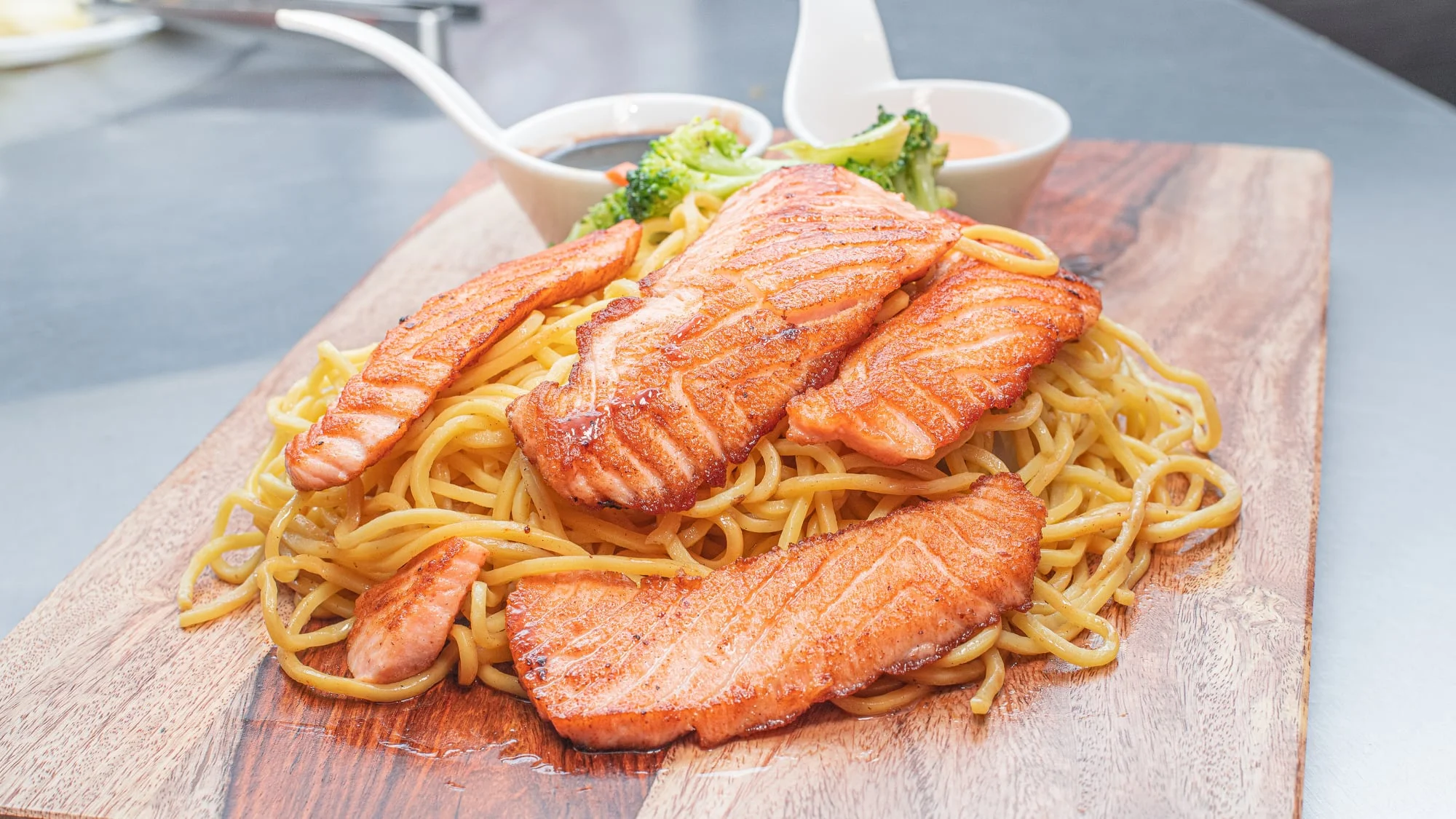 Grilled salmon over stir-fried noodles