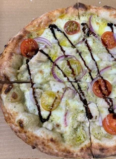 Gourmet chicken pesto pizza with cherry tomatoes