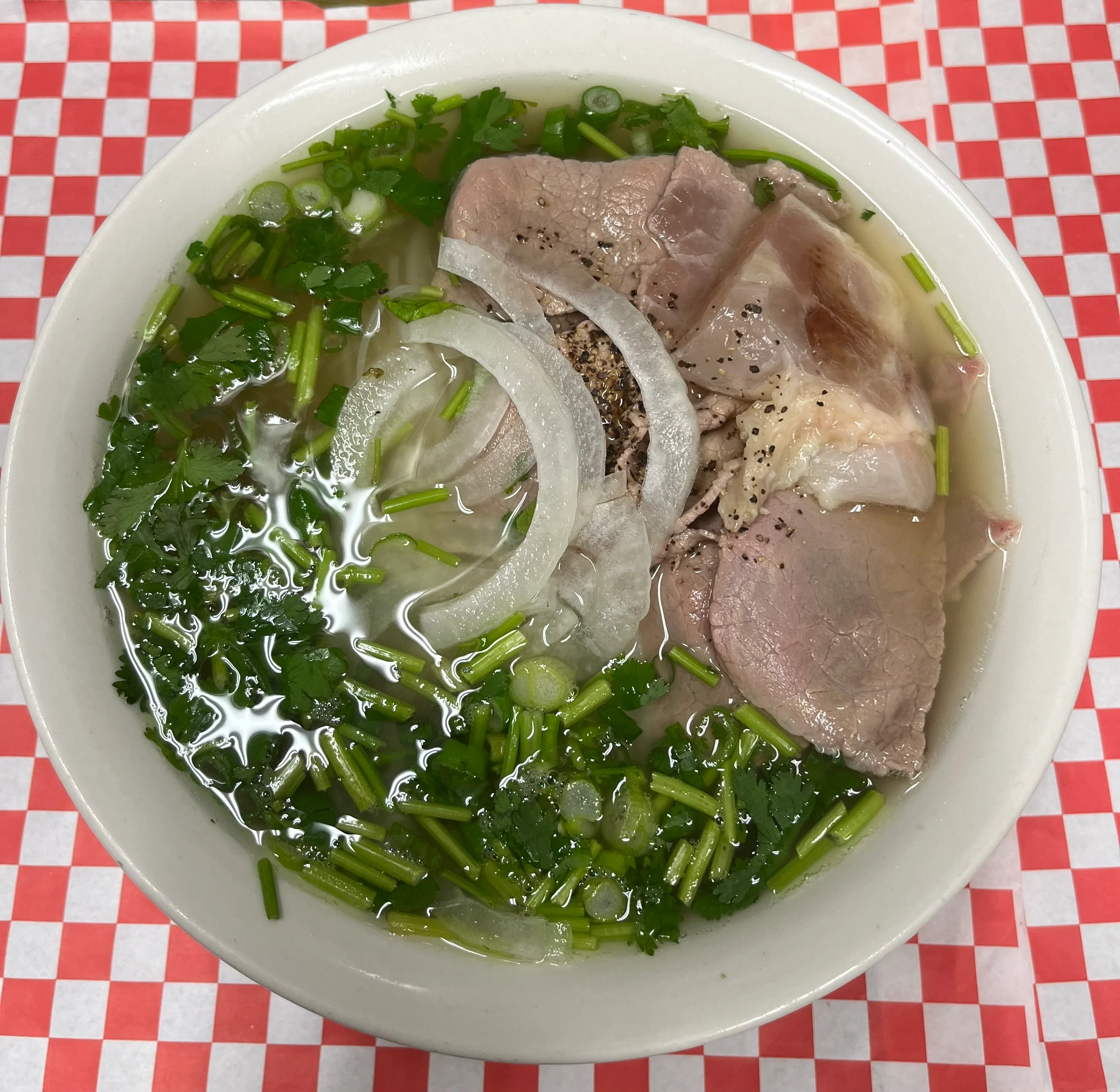 Bowl of Vietnamese pho with tender beef and fresh herbs