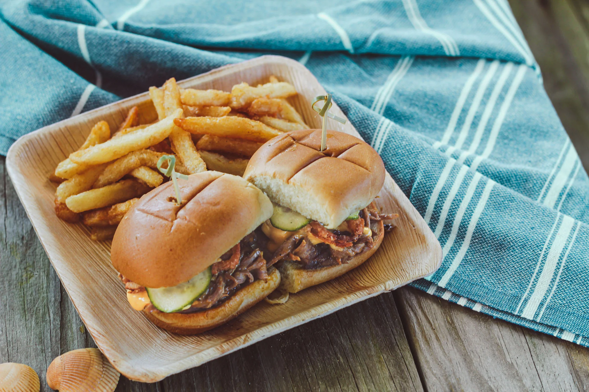 Pulled pork sliders with fries on a wooden platter