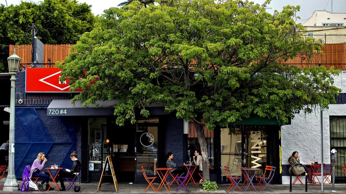Charming café exterior with outdoor seating and lush greenery