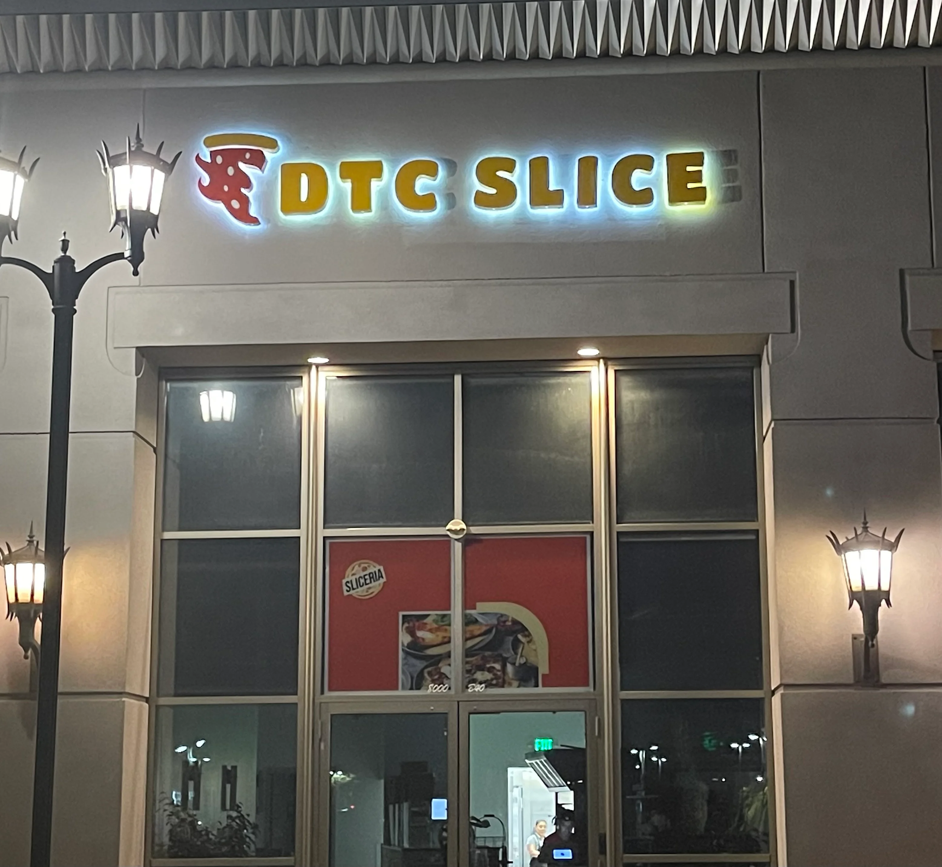 DTC Slice restaurant exterior with illuminated signage at night