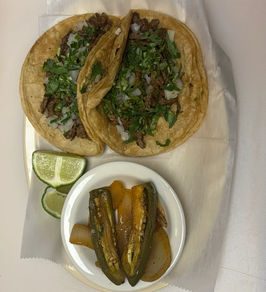 Authentic Mexican tacos with grilled meat and garnishes served with jalapeños and lime