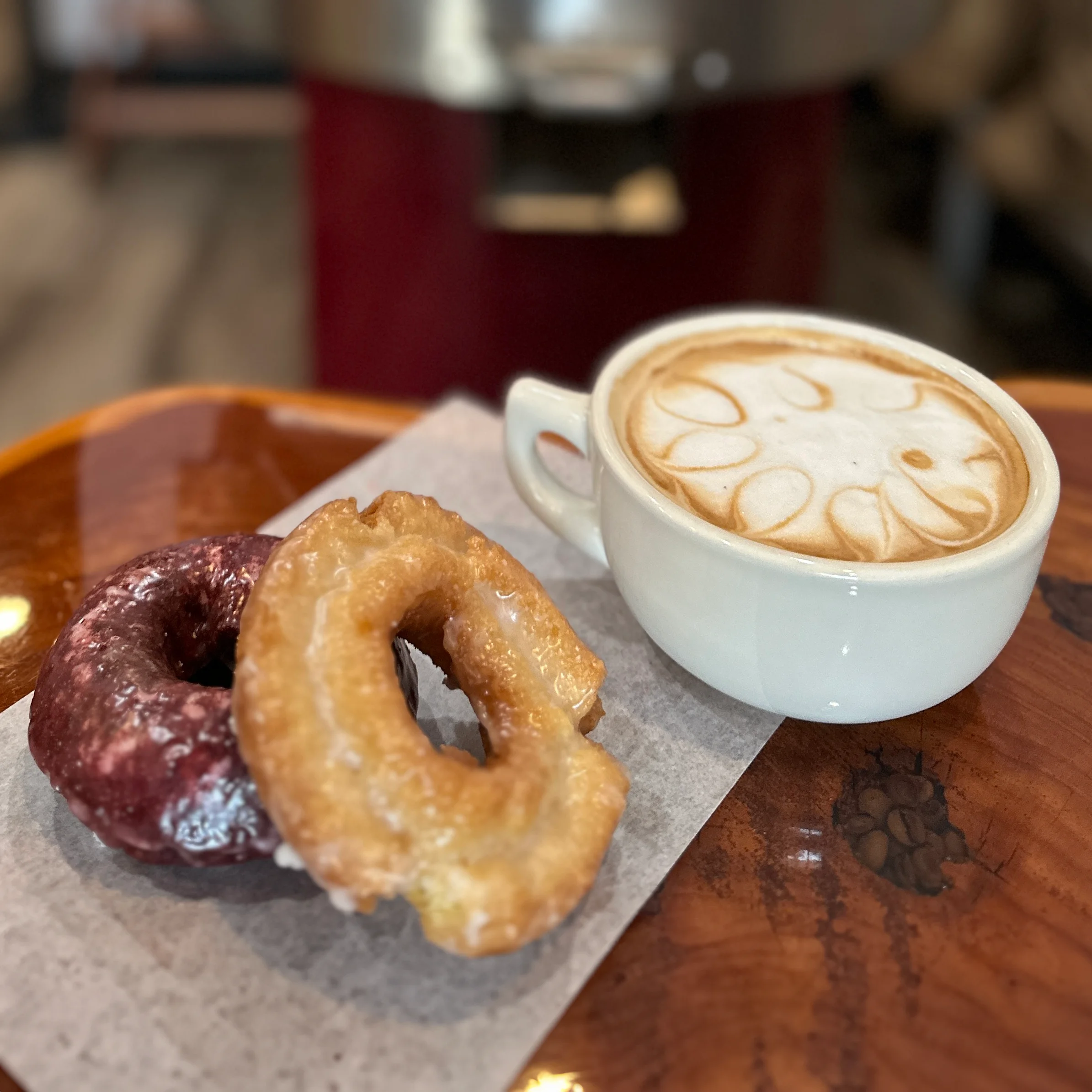 Freshly brewed latte with donuts on a wooden table