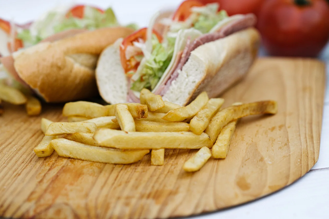 Classic sub sandwich with fries on a wooden board