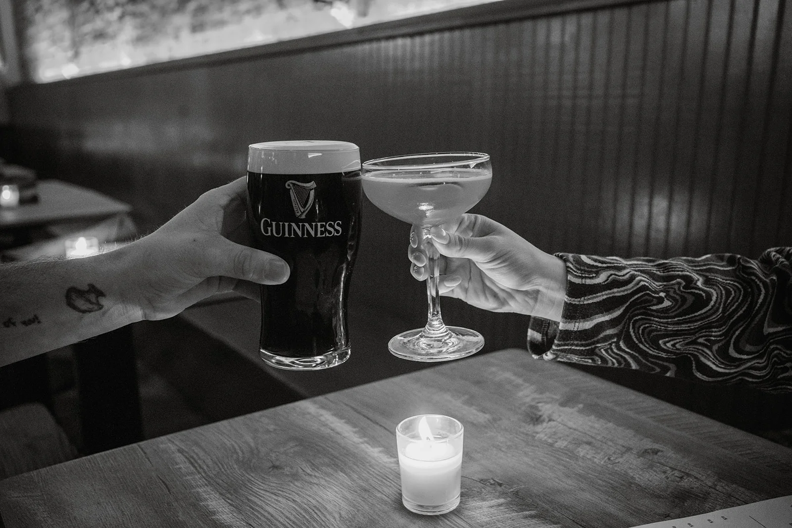 Cheers with a pint of Guinness and a cocktail in a cozy restaurant setting