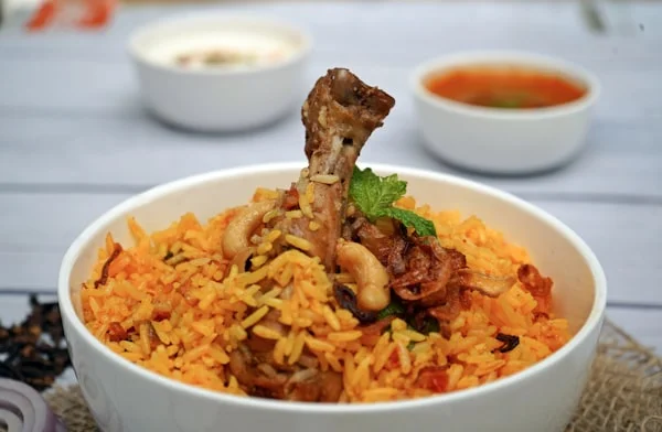 Bowl of aromatic biryani with tender chicken and spices