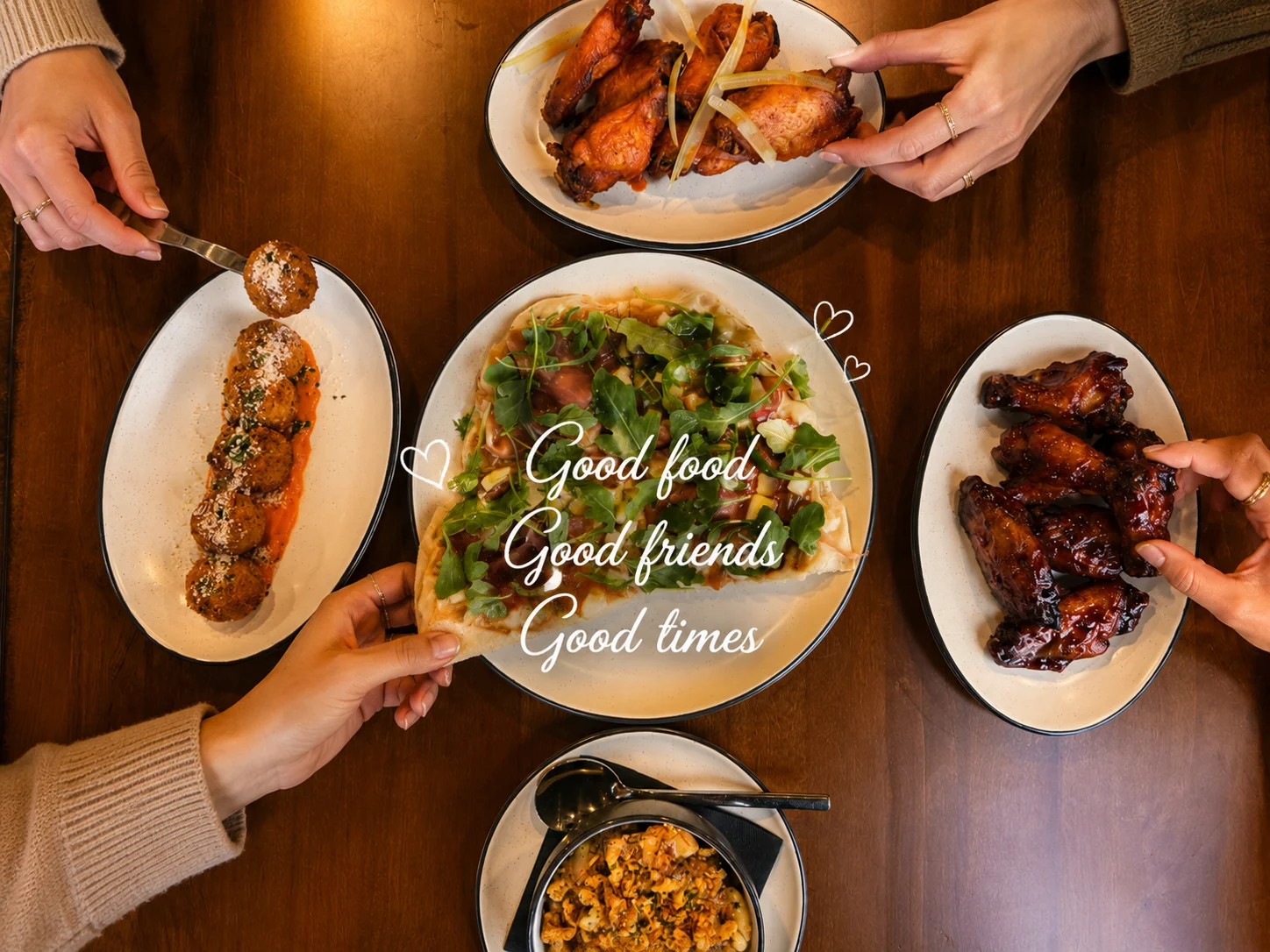 Assorted appetizers including wings and meatballs in a cozy dining setting
