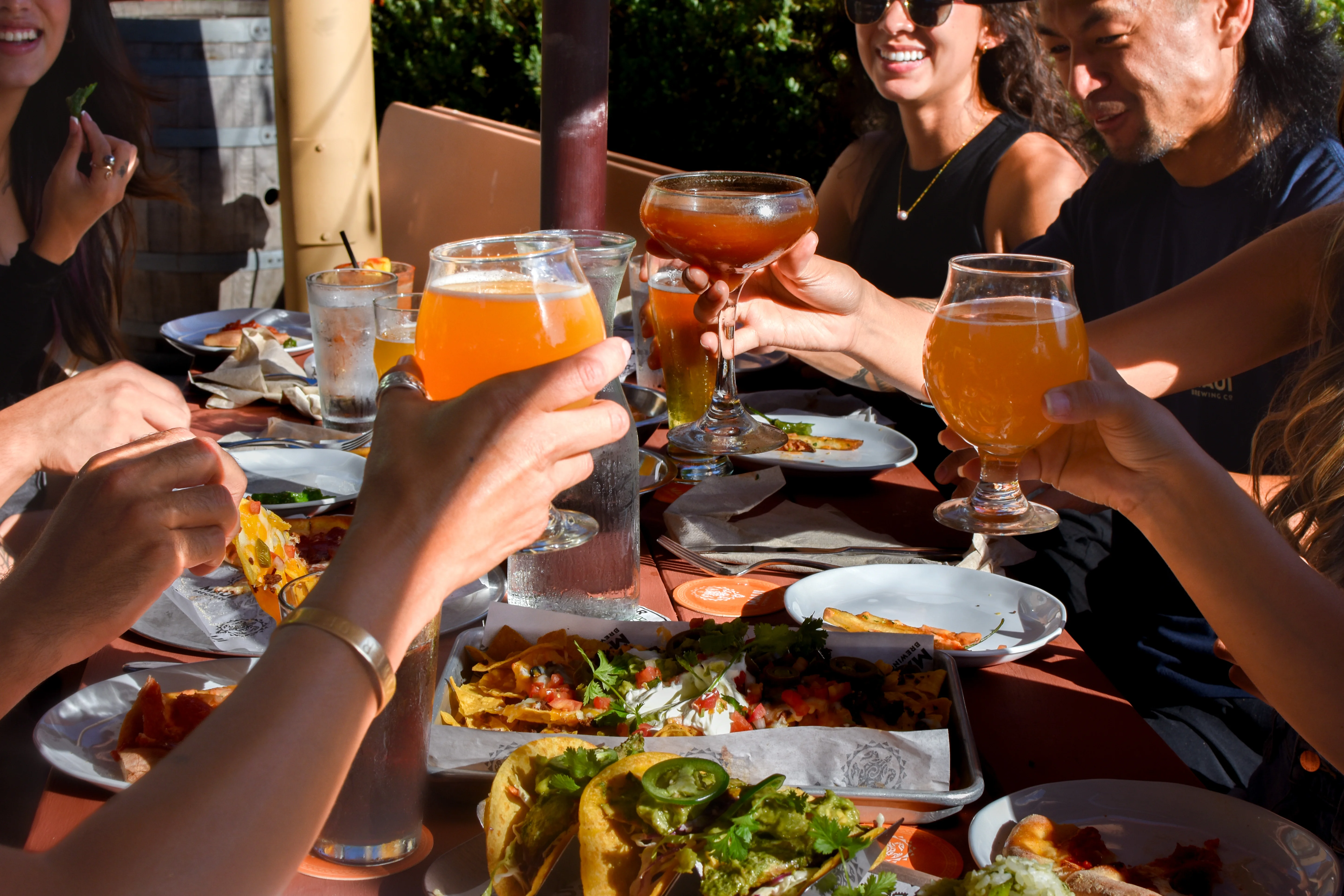 Cheers with craft beers and tacos at a lively outdoor dining table