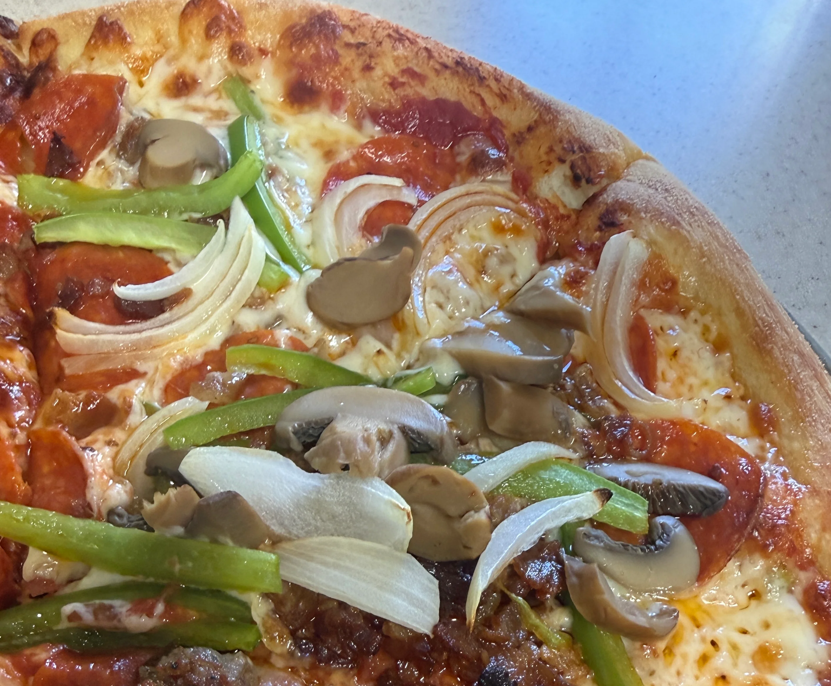 Delicious pepperoni pizza topped with green peppers and mushrooms