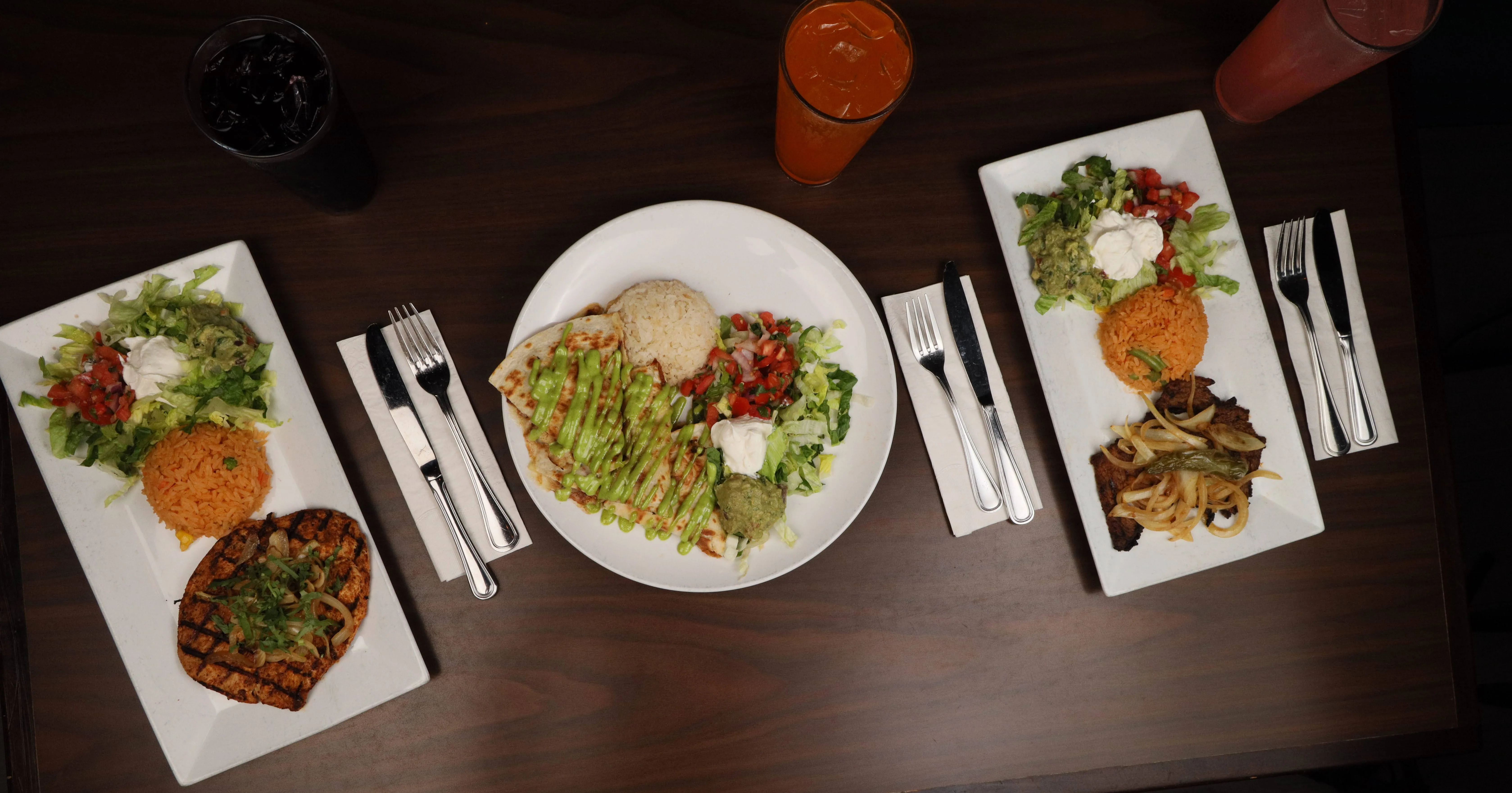 Delicious Mexican dishes with guacamole, rice, and a refreshing drink.