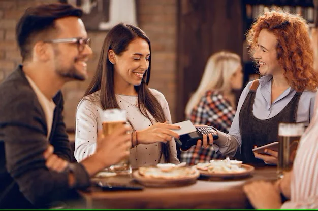 Friends enjoying drinks and food at a lively bar