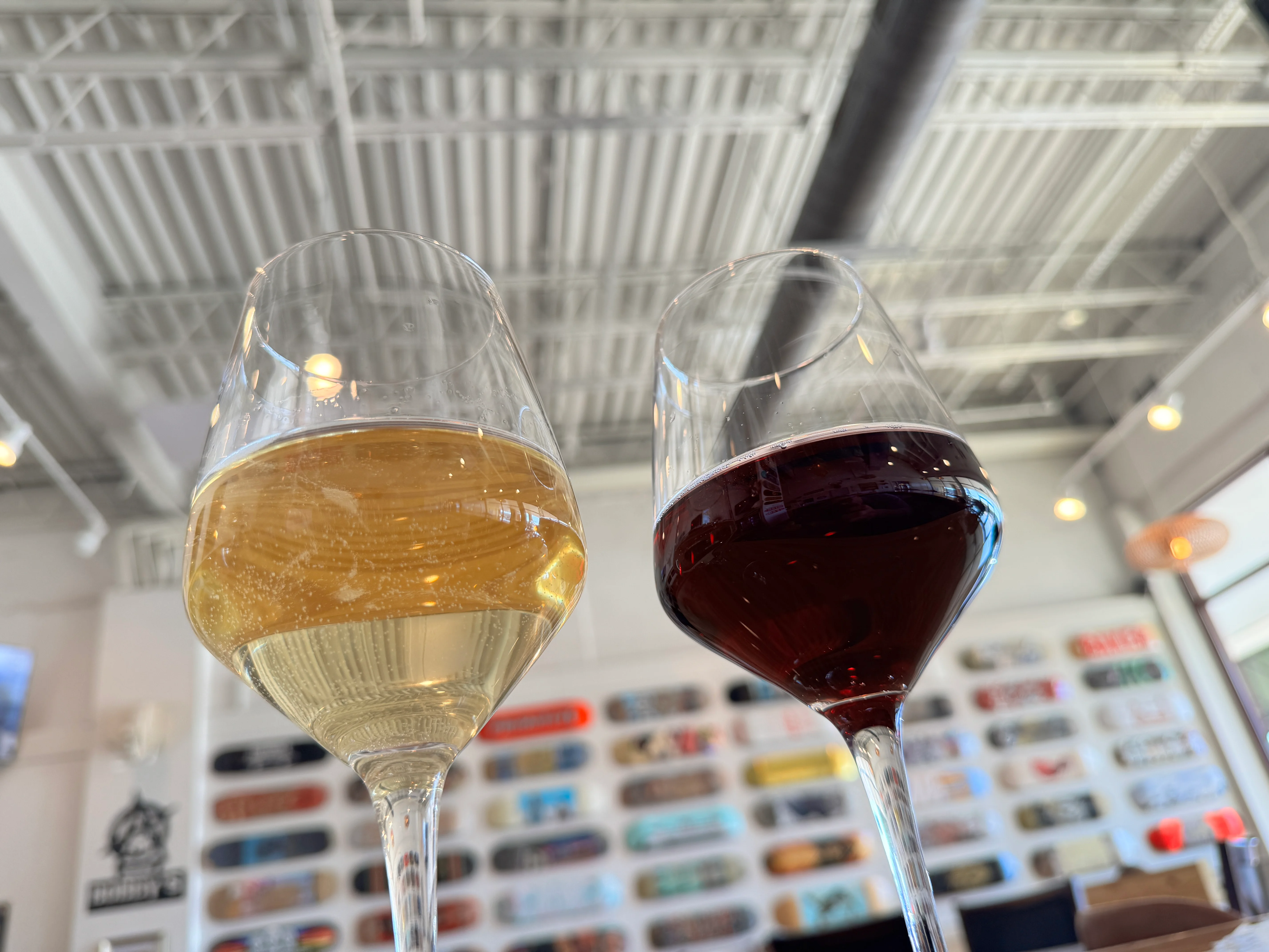 Two wine glasses with white and red wine in a modern restaurant setting