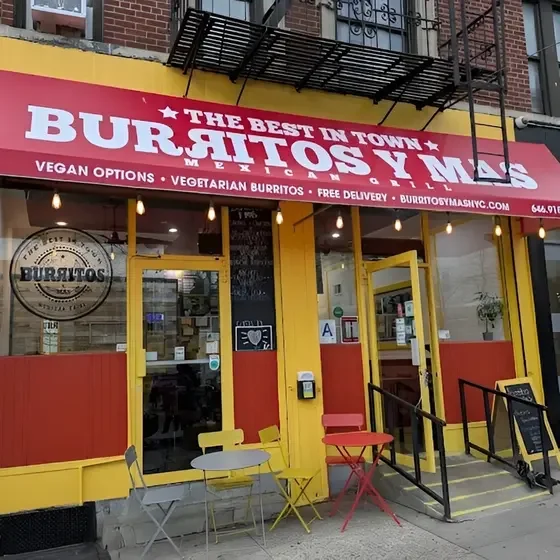 Colorful restaurant exterior of Burritos y Mas with outdoor seating
