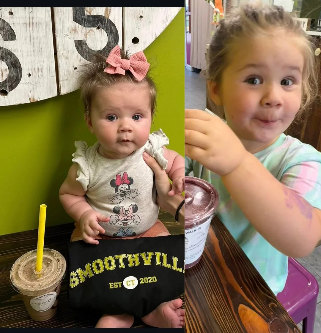 Two children enjoying smoothies at a vibrant café